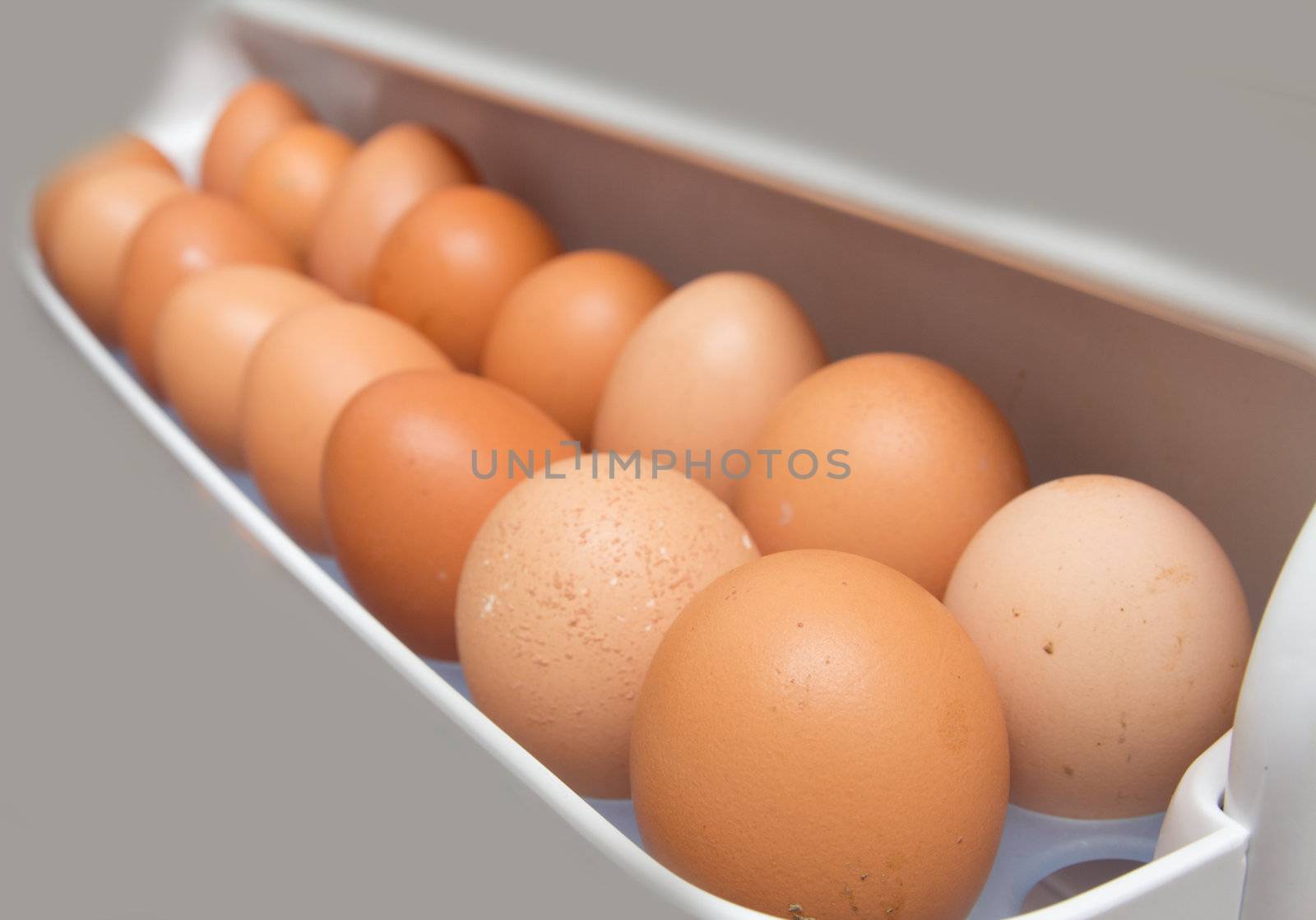 closeup of a pile of brown eggs in the fridge 