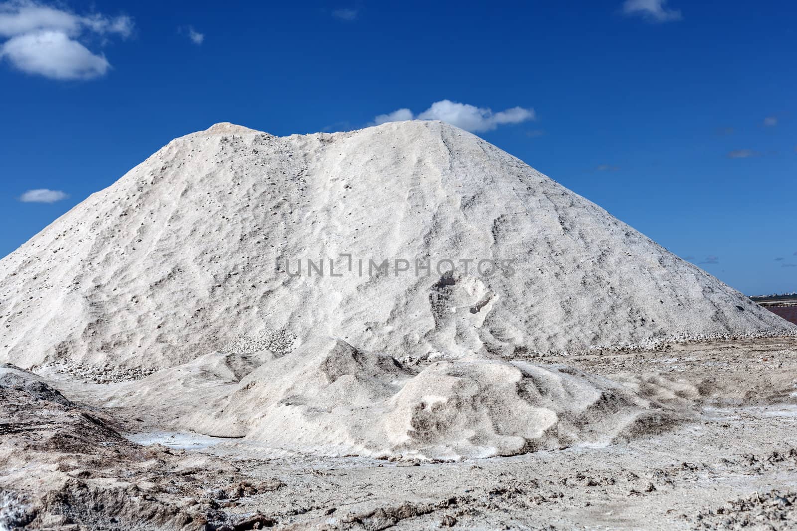 Big pile of freshly mined salt, set against a blue sky