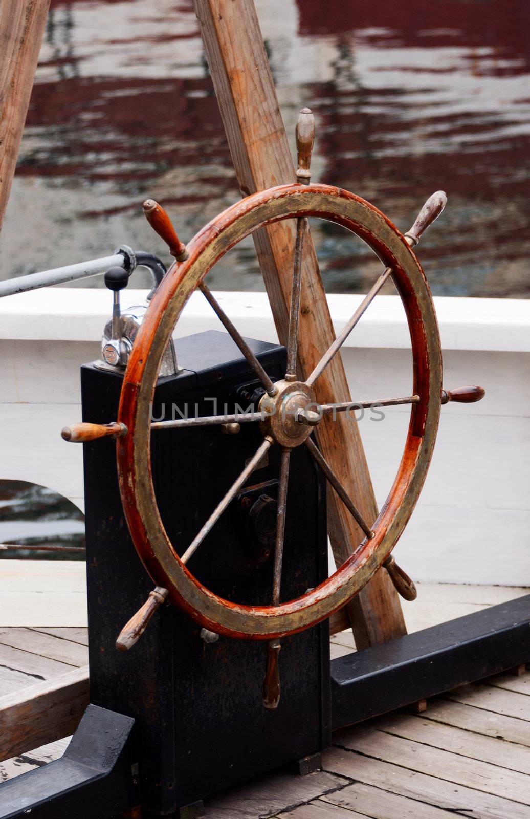 Wooden steering wheel on old sailboat by Nanisimova