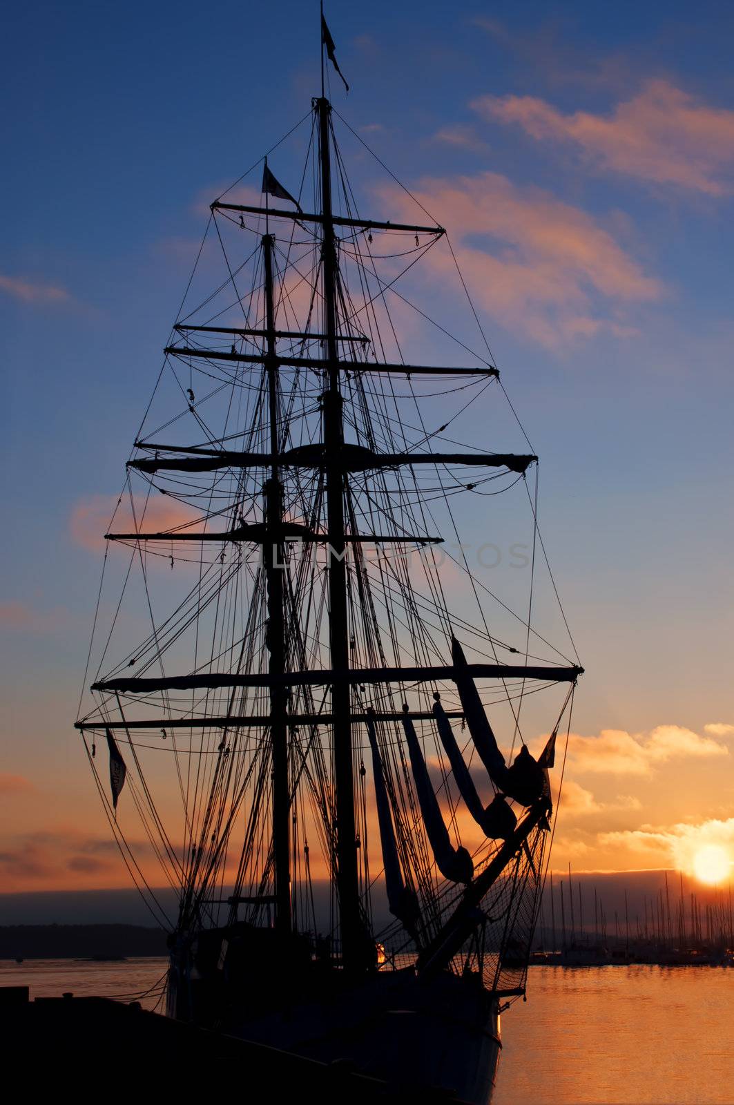 Tall ship silhouette at sunset at pier