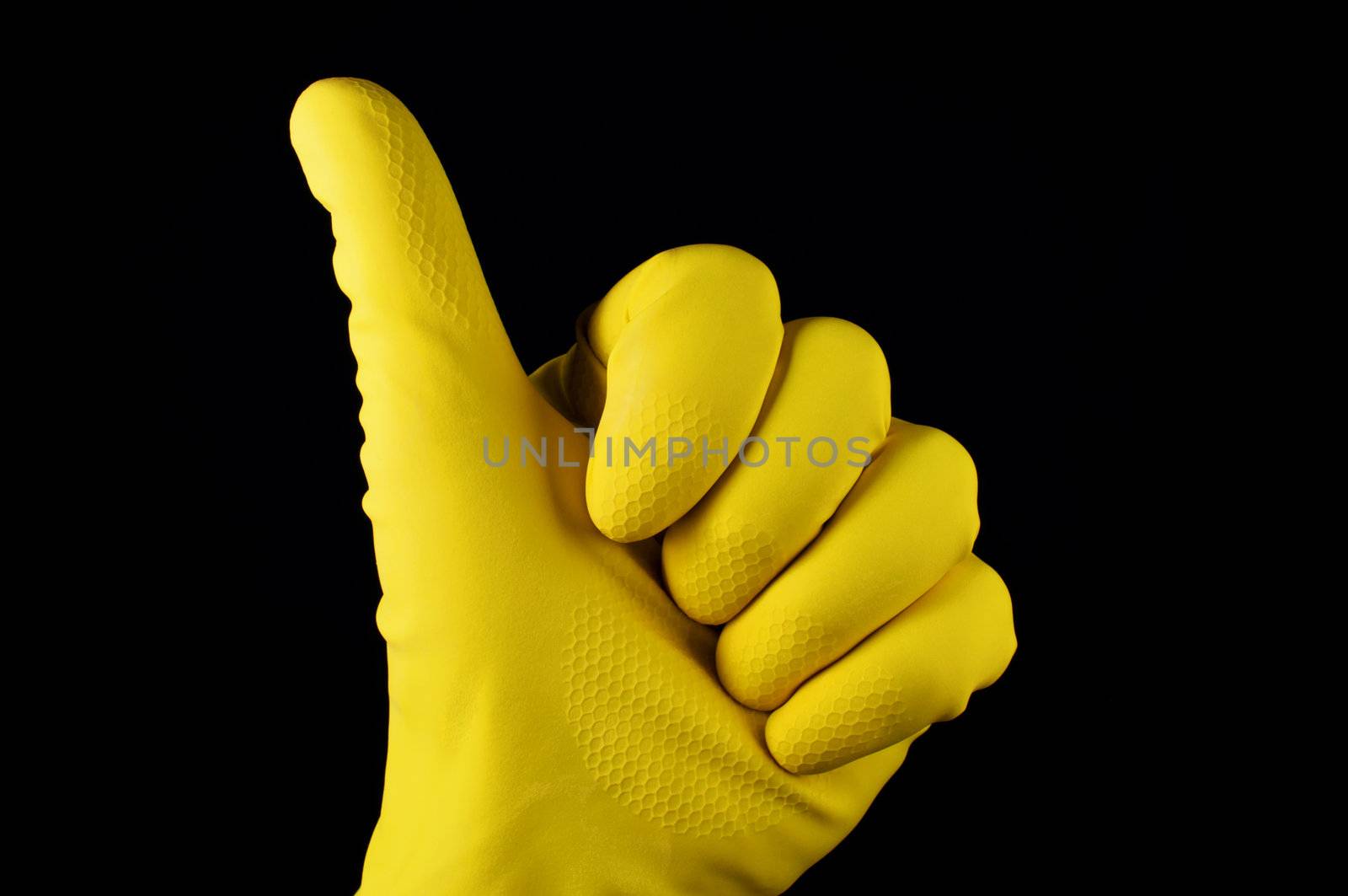 Thumb up in yellow rubber glove on black background