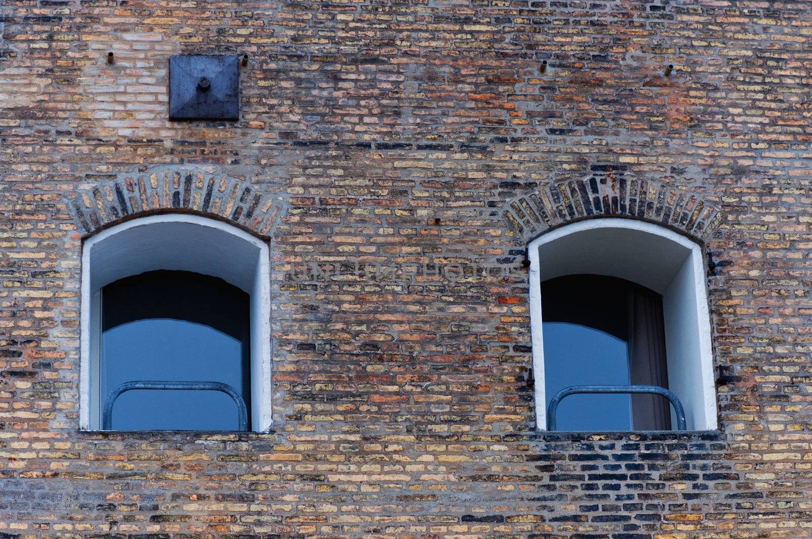 Two  windows on brick background