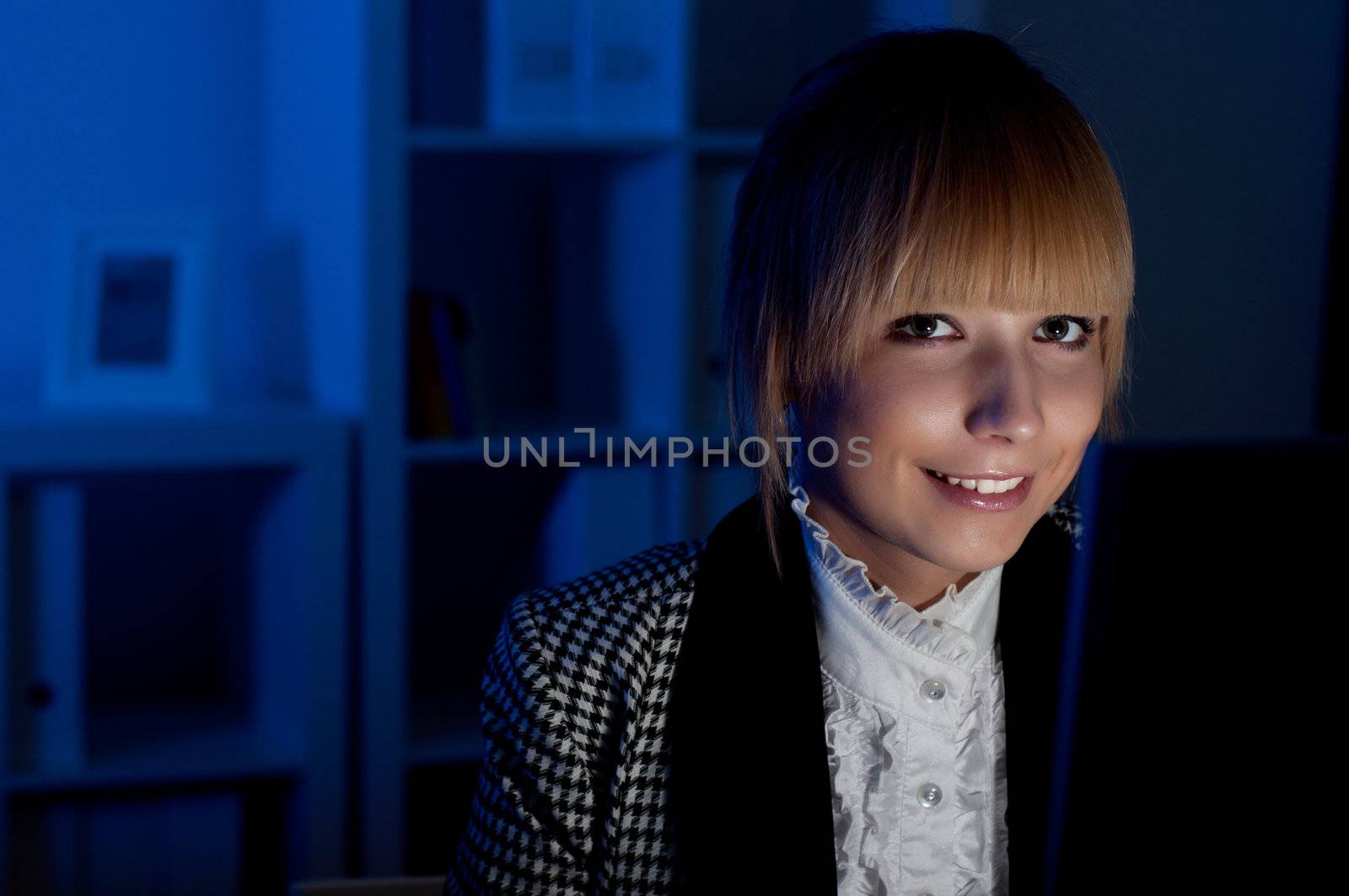 beautiful young business woman working at night in the office