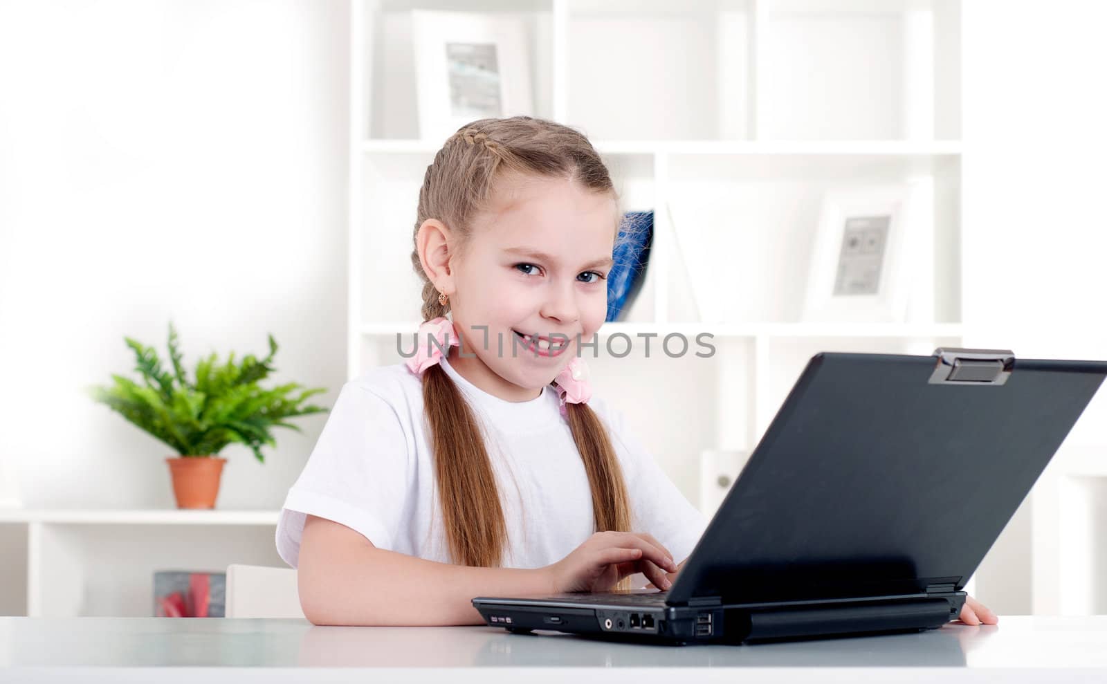 girl working on laptop at home, sitting at the table