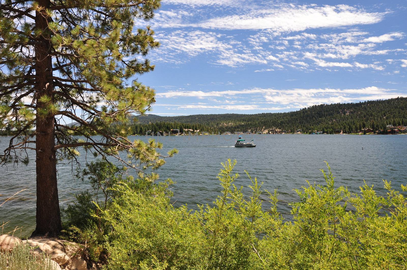A lone boat makes its way across Big Bear Lake in the Southern California mountains.