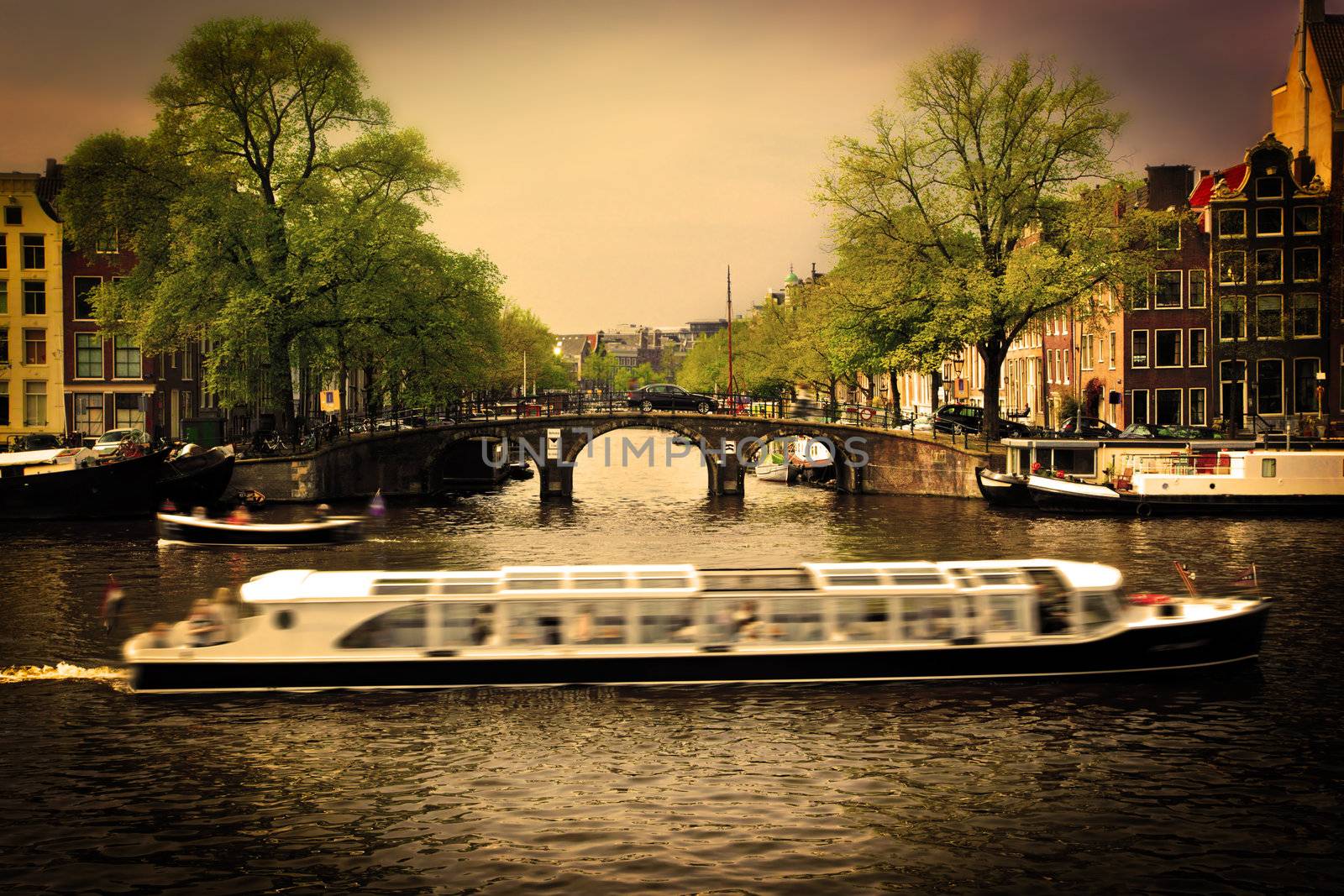 Amsterdam, Holland, Netherlands. Romantic bridge over canal, cabin cruiser. Old town