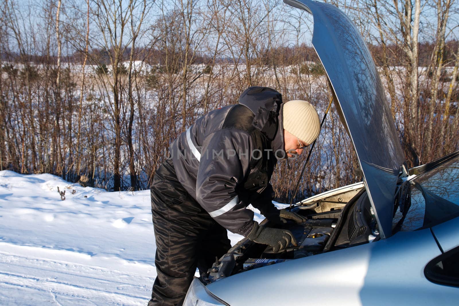 man checked the broken car engine in cold winter day