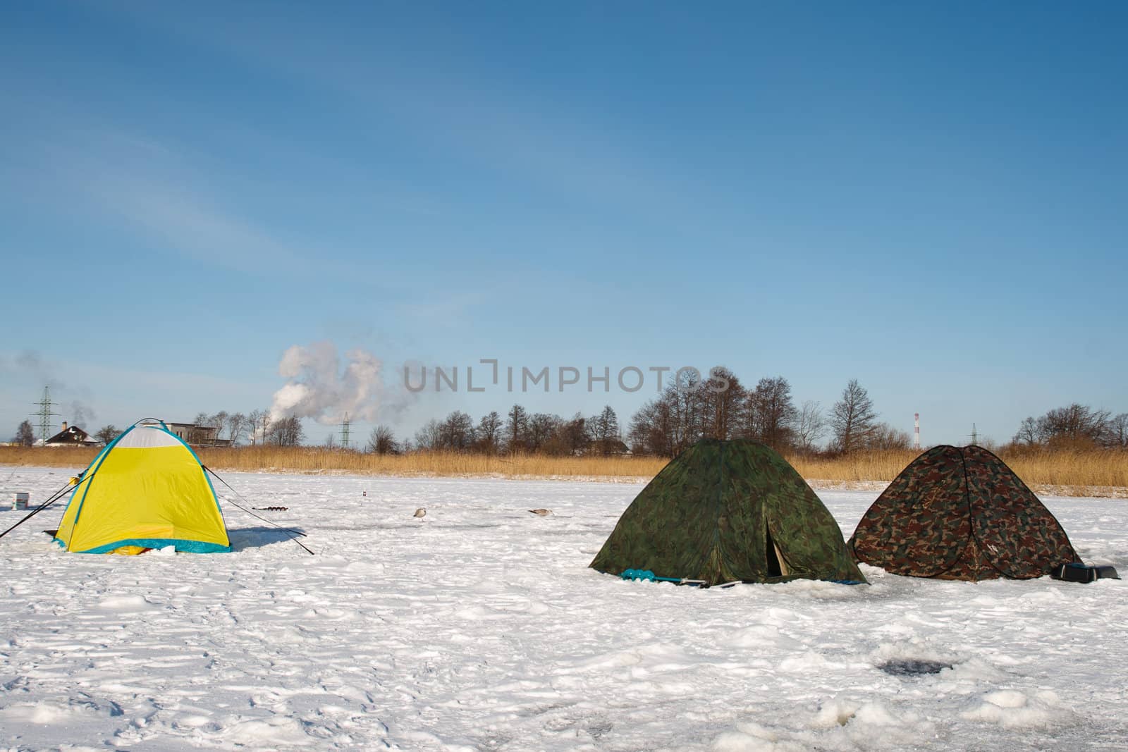 Winter fishermen tents on frozen river