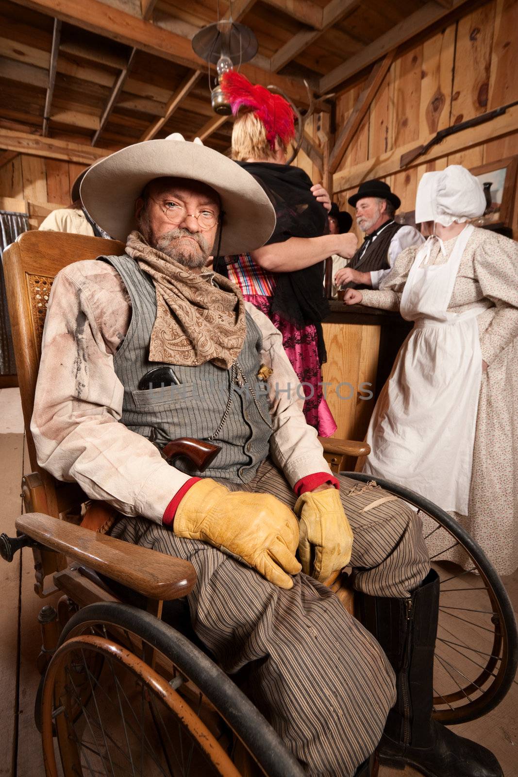 Injured mature cowboy in wheelchair at old west saloon