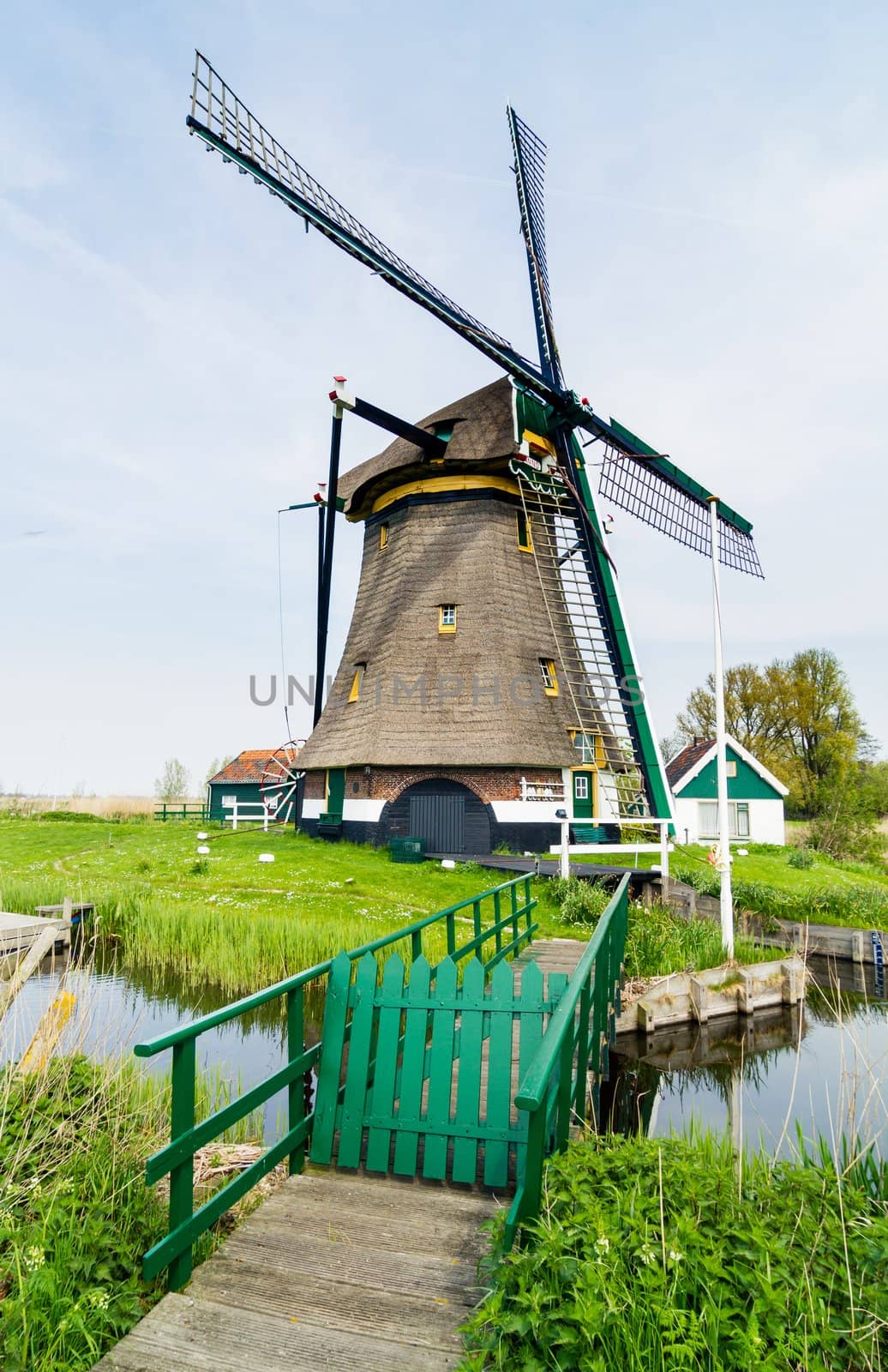 A traditional Dutch windmill near the canal. Netherlands. Vertical view