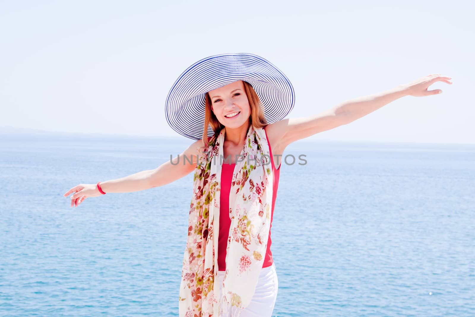 Young and beautiful girl resting on rocks against the sea