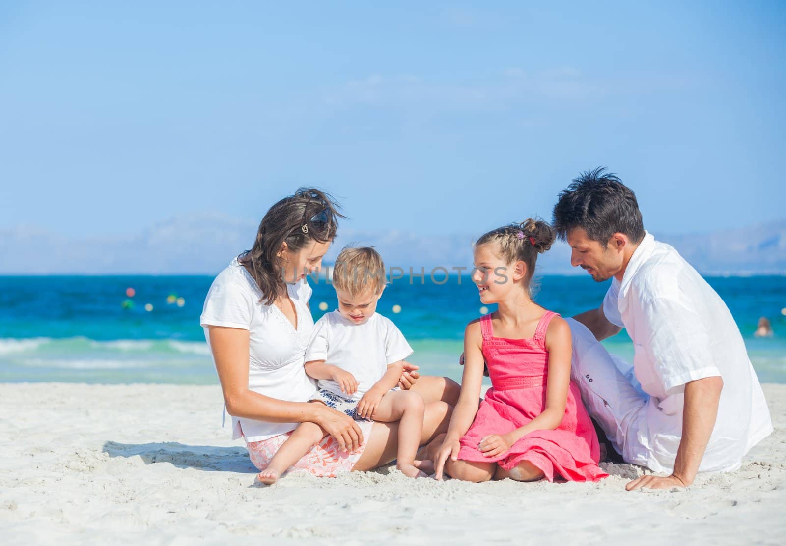 Family of four having fun on tropical beach