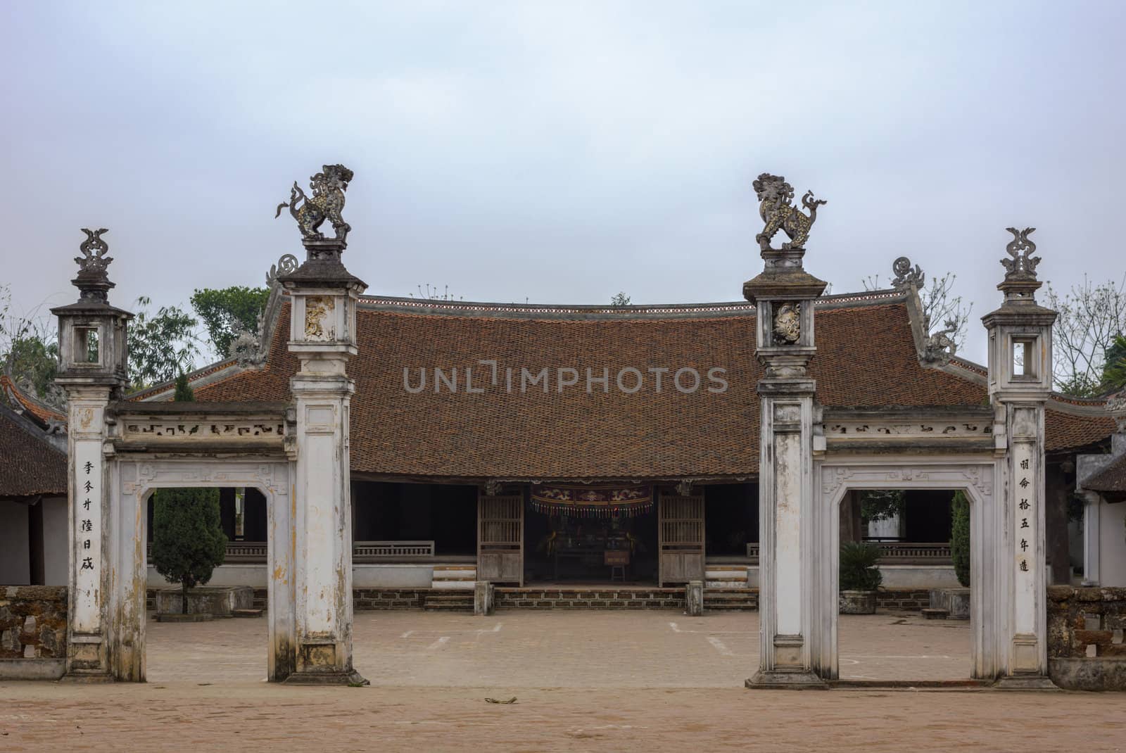 Centuries old wooden construction with red tiled roof and gate with lions.