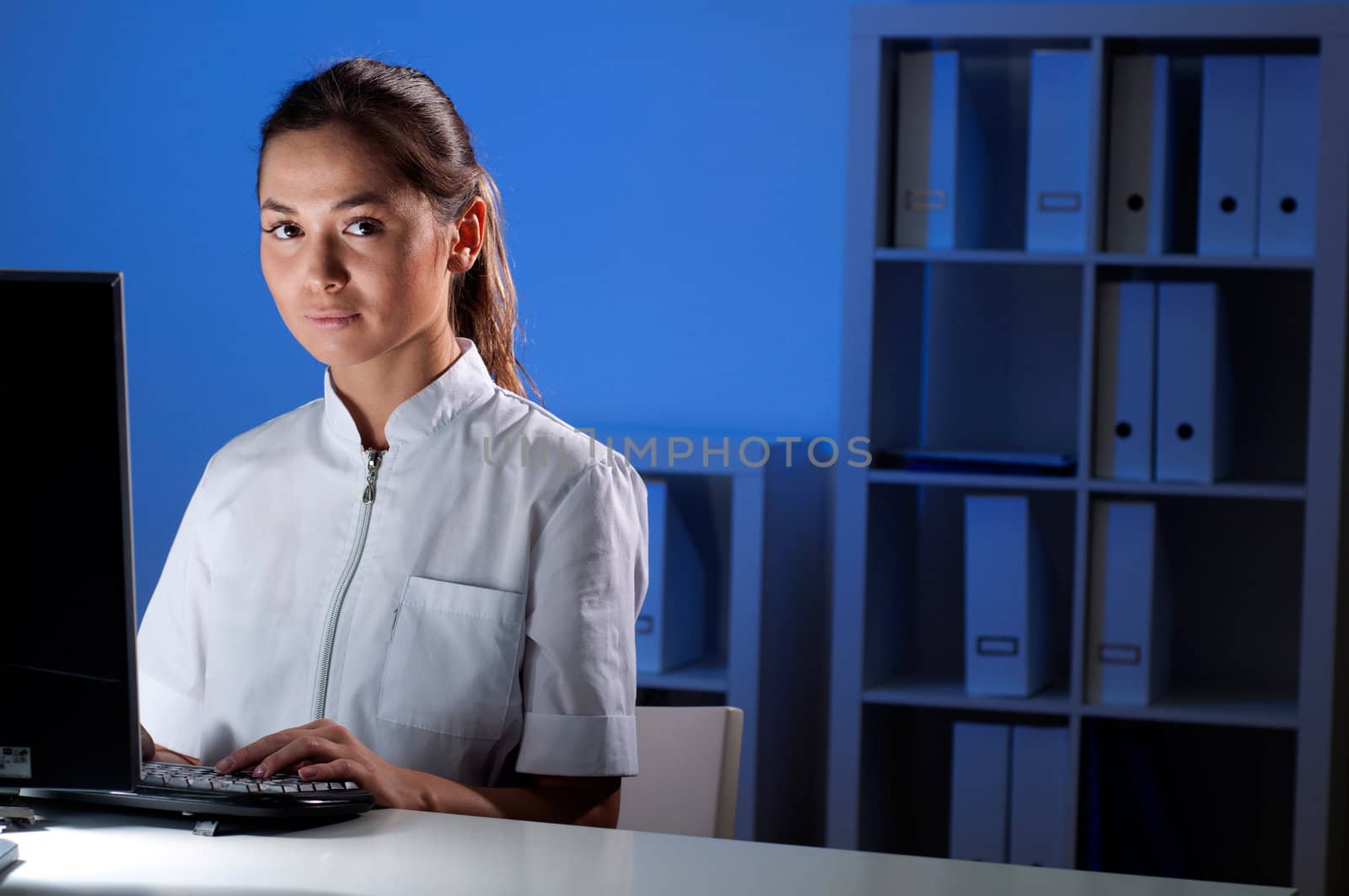 beautiful young woman doctor working at night in the office