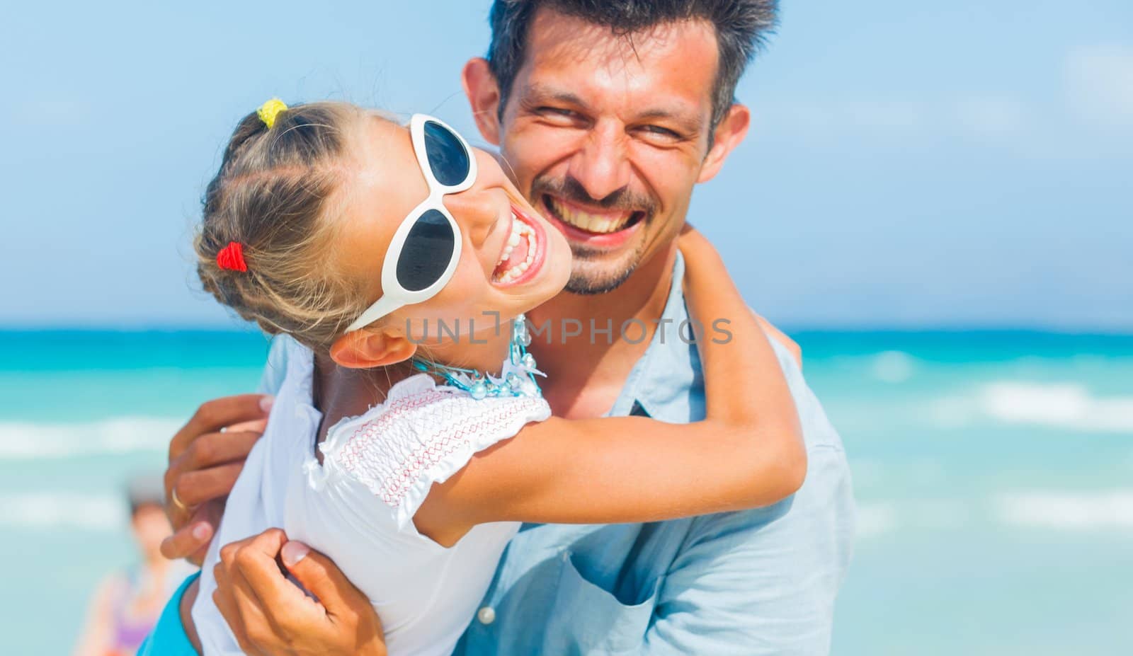 Father and daughter having fun on tropical white sand beach