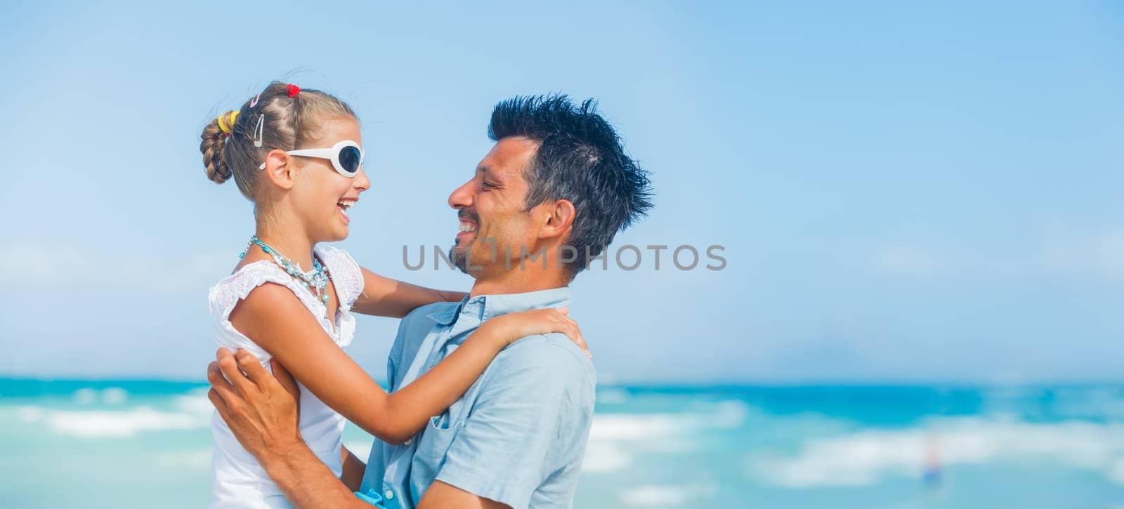 Father and daughter having fun on tropical white sand beach
