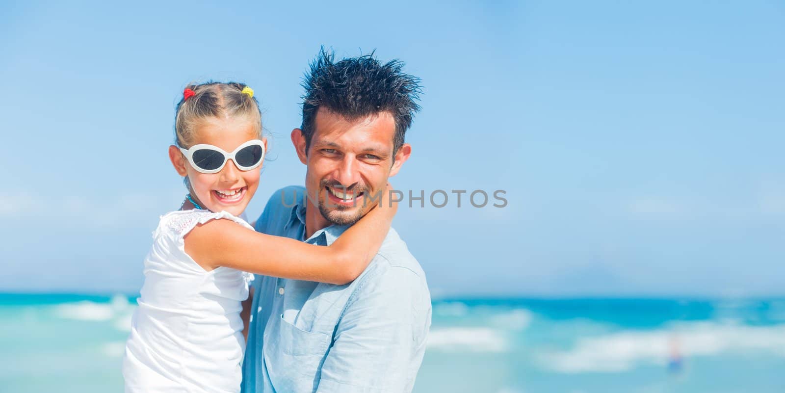 Father and daughter having fun on tropical white sand beach