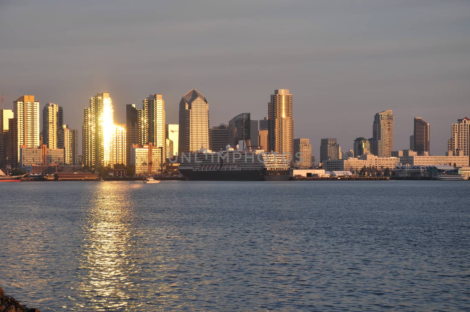 The fading rays of afternoon sunlight reflect off of the downtown towers in San Diego, California.