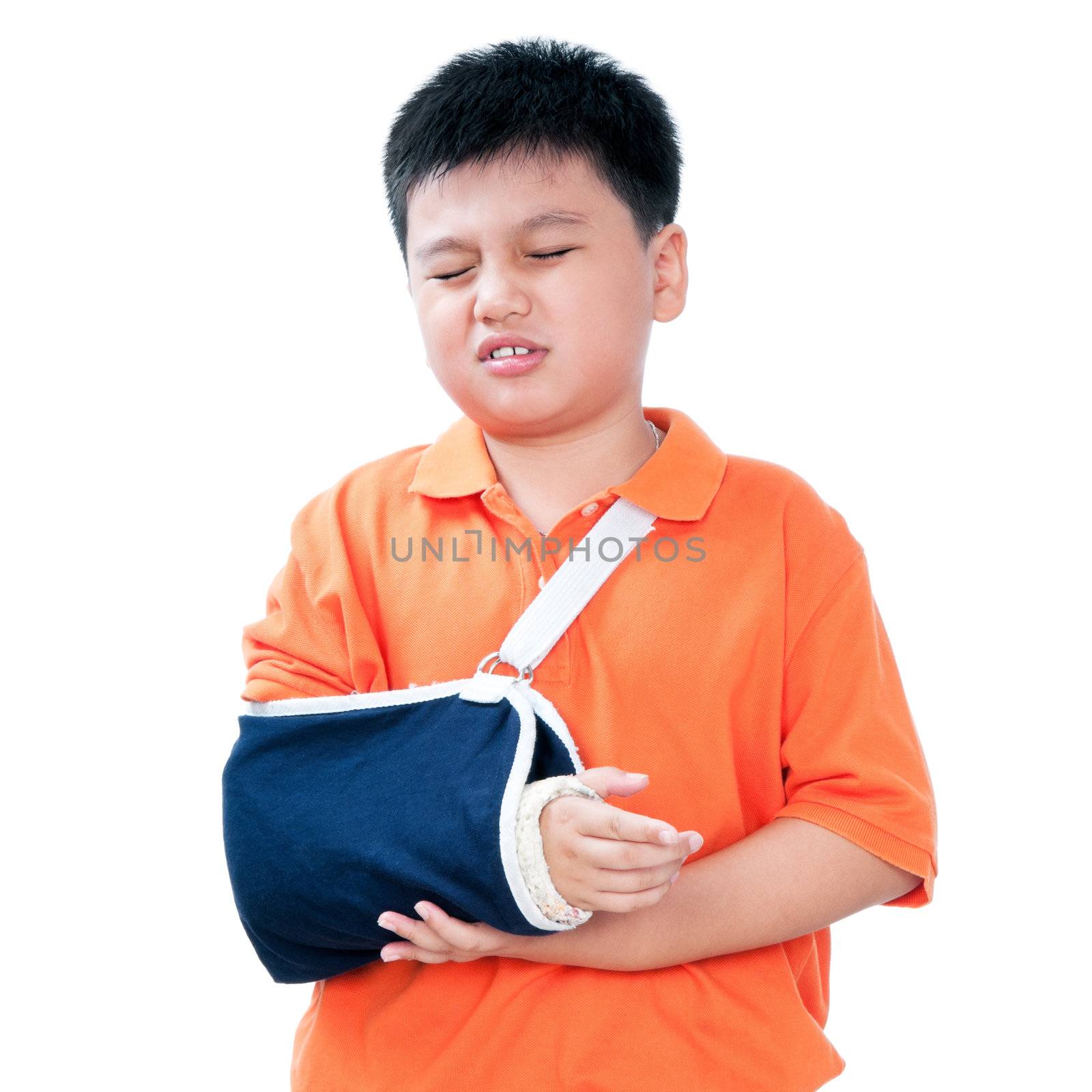 Portrait of a young Asian boy in pain with broken arm in plaster cast, isolated on white background.