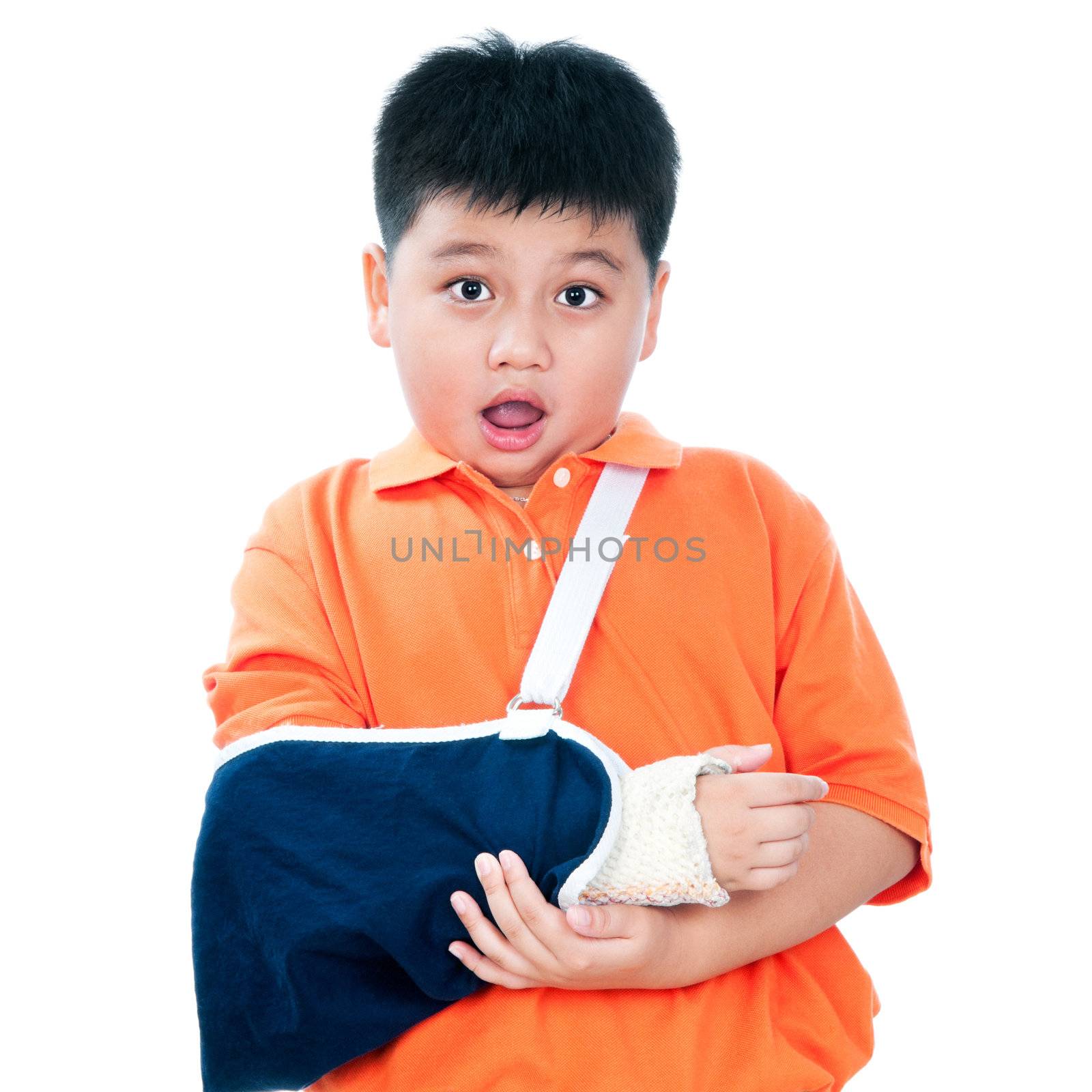 Portrait of a young Asian boy with fractured hand in plaster cast over white background.