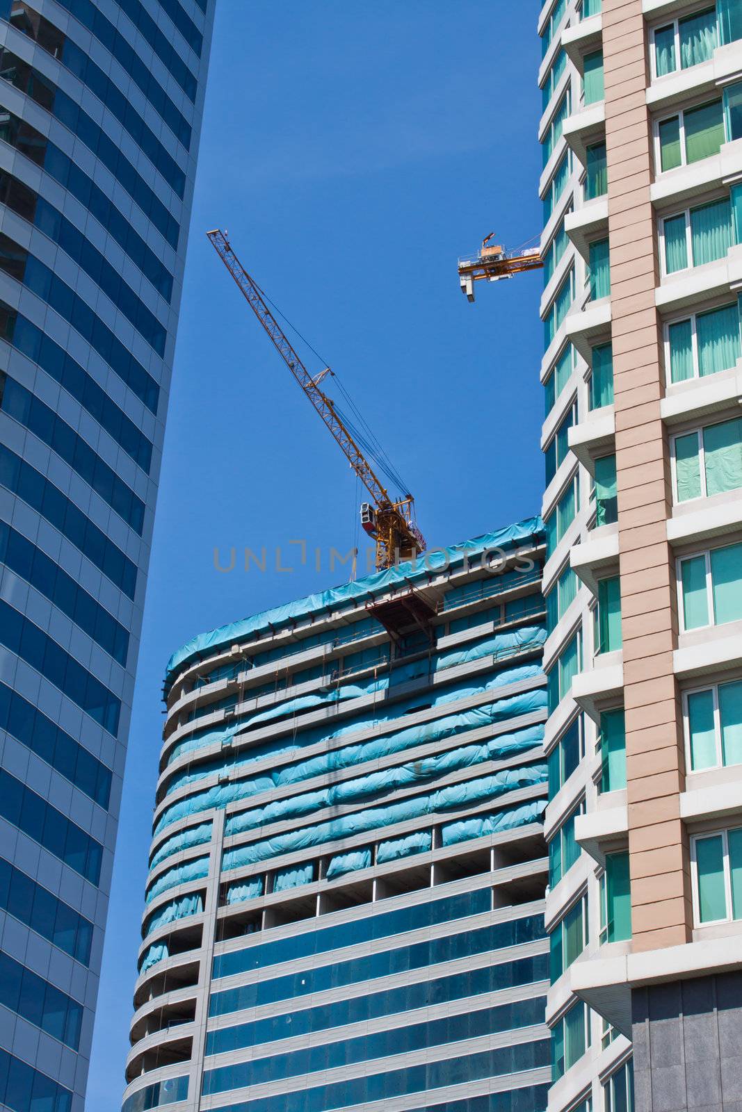 tall buildings under construction under a blue sky