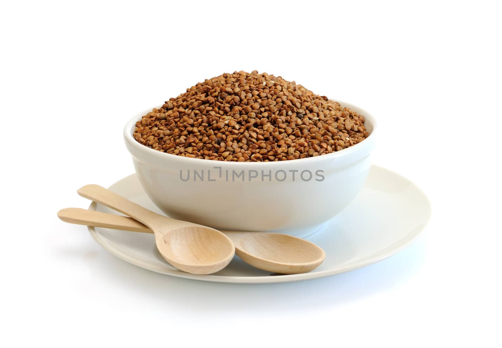Buckwheat in a bowl on a white background with wooden spoons