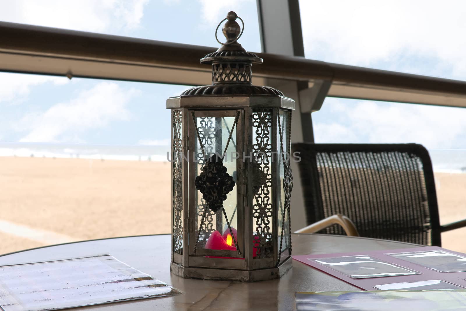A candle in a decorative candlestick at the beach cafe. Den Haag by NickNick
