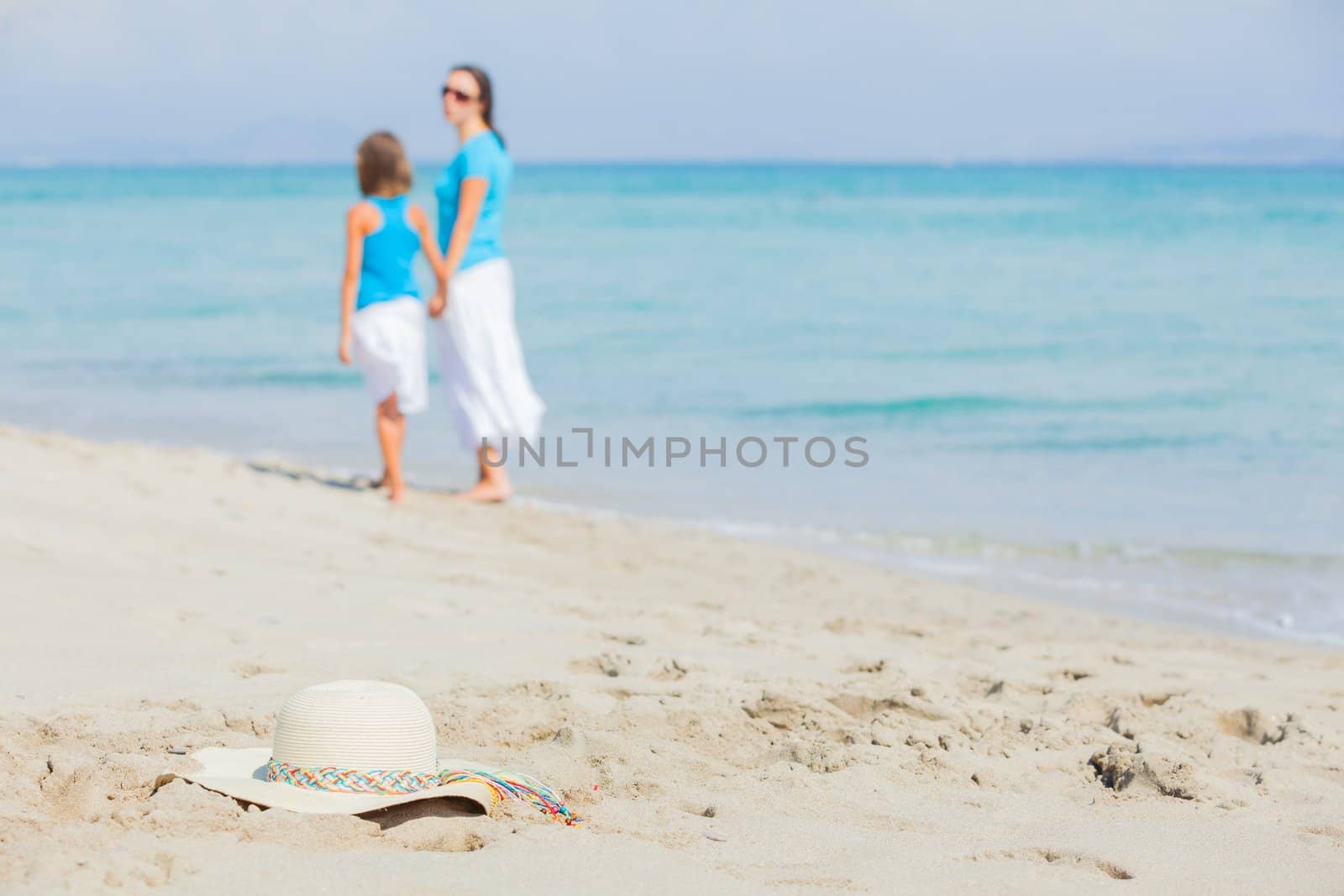 Photo of straw beach hat on exotic white sand beach