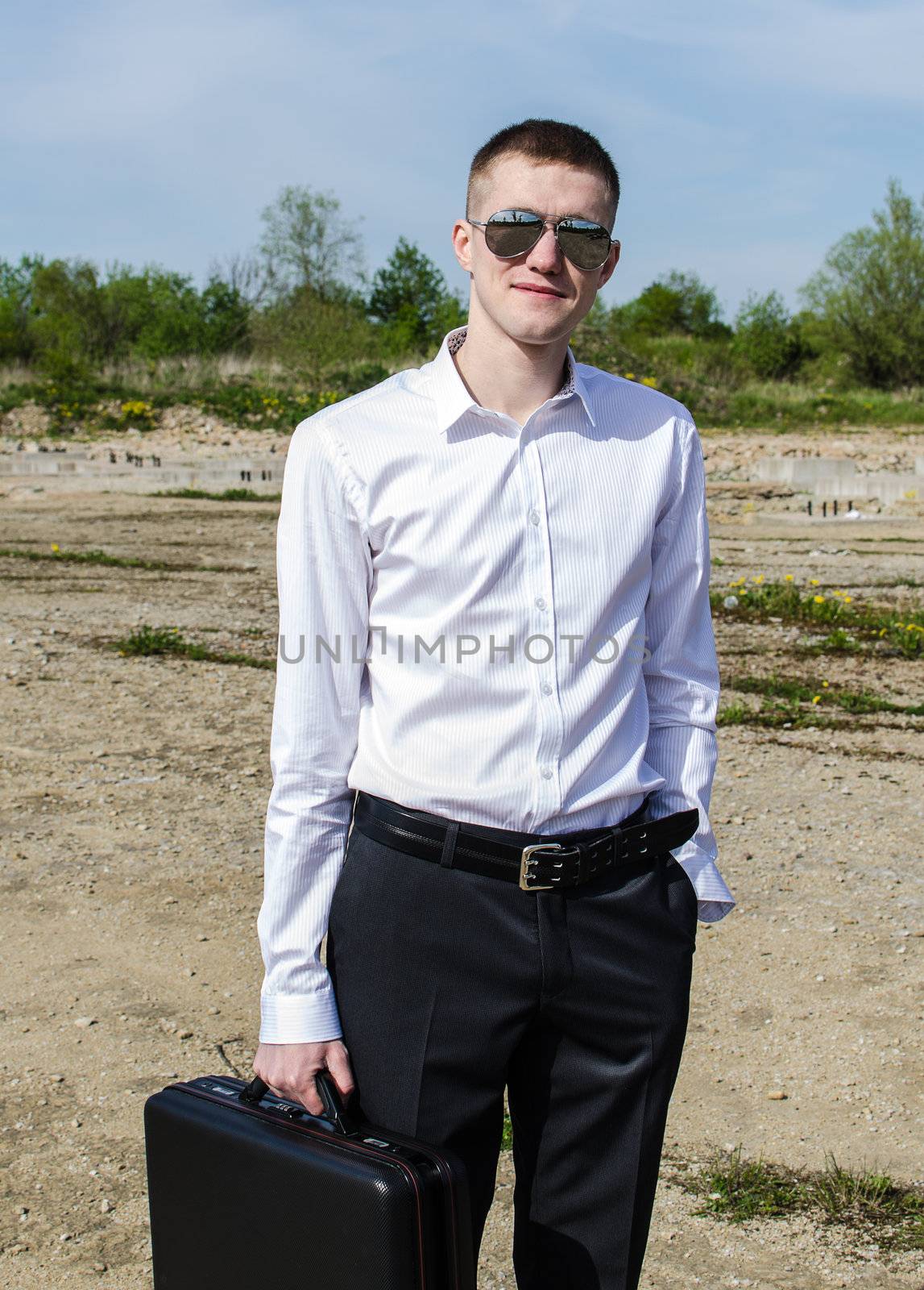 Businessman in glasses with a suitcase in his hand