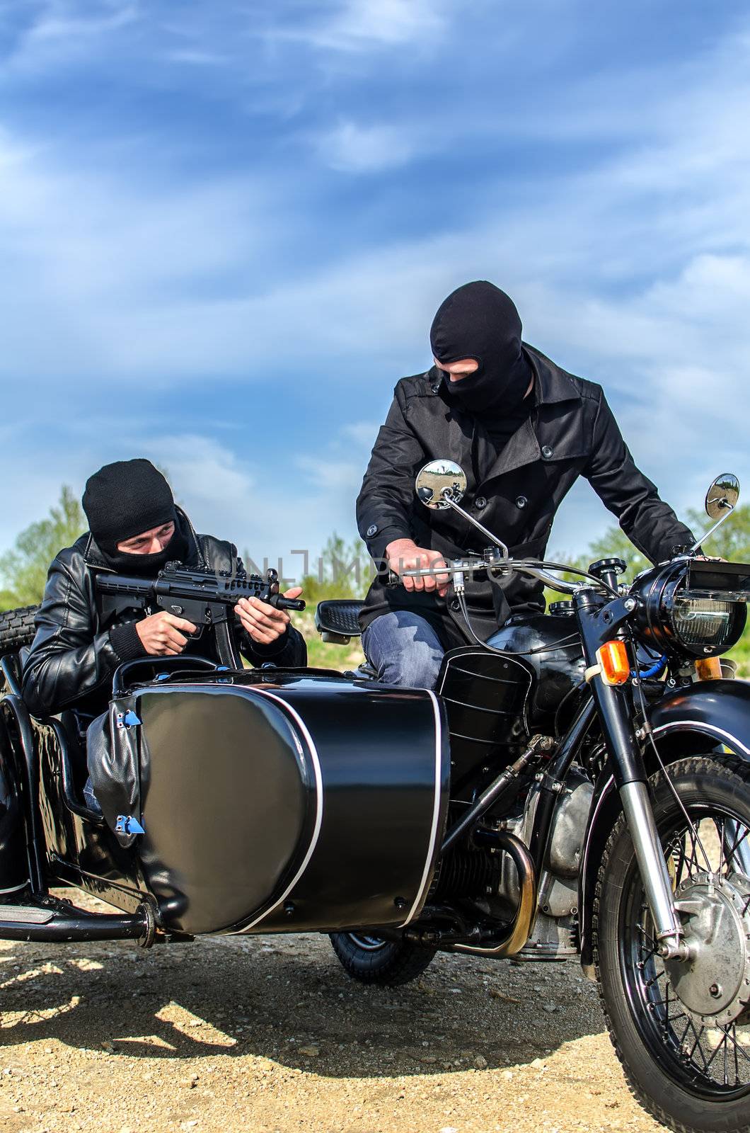 Two armed men riding a motorcycle with a sidecar