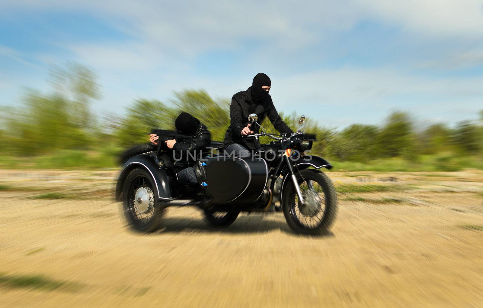 Two armed men riding a motorcycle with a sidecar. Motion blur. by dmitrimaruta