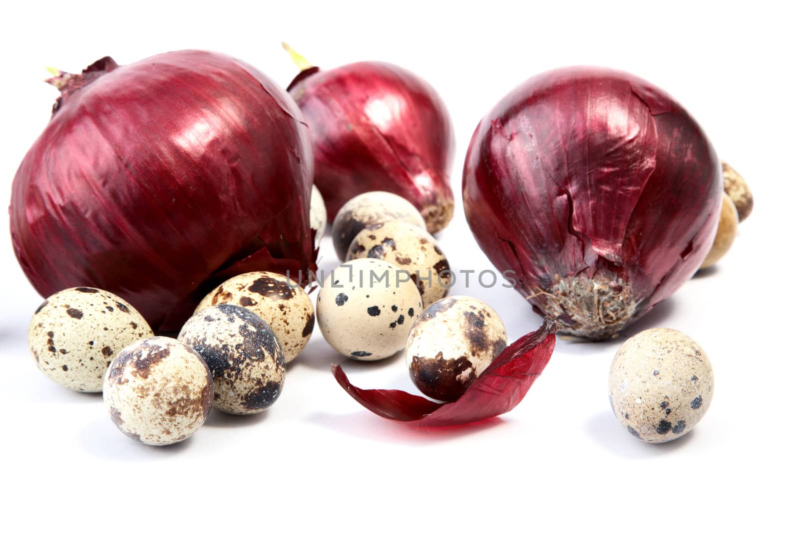 Red onions and quail eggs on a white background