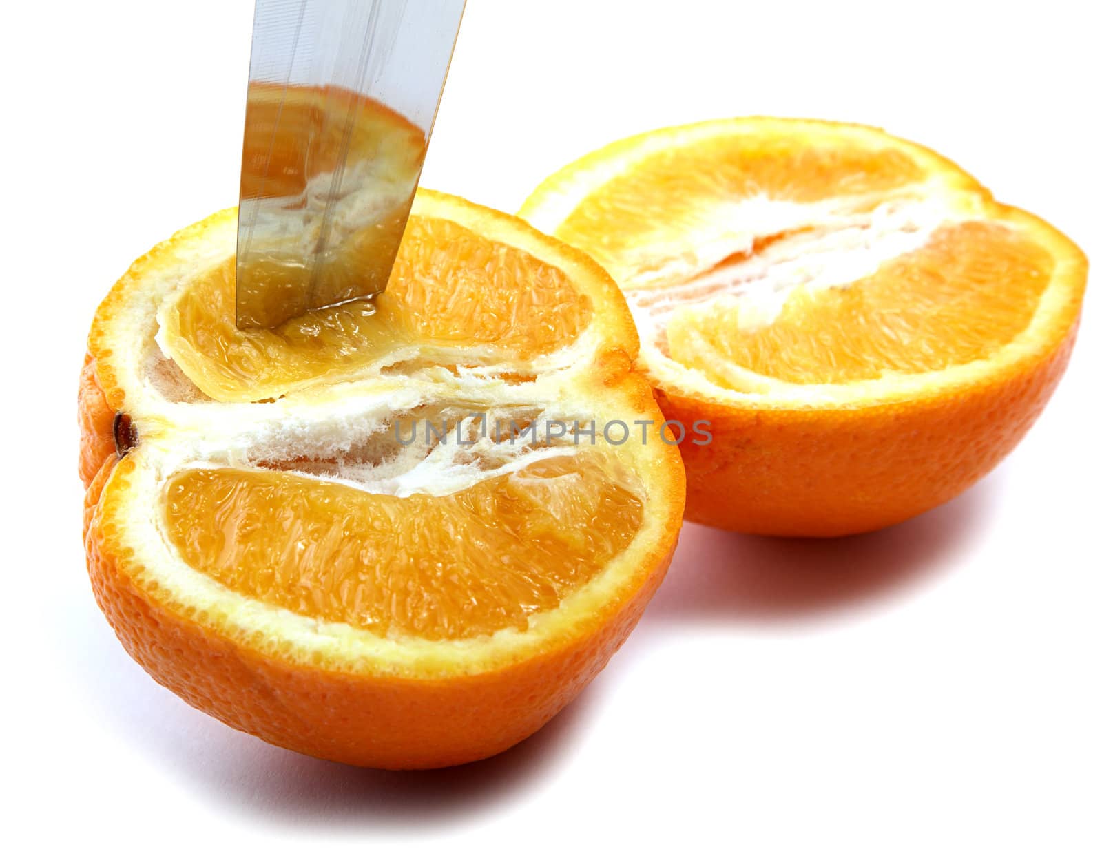 Knife and orange cut half-and-half on a white background