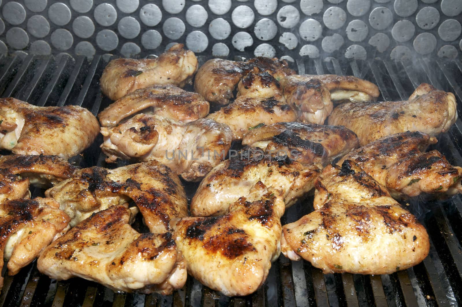 cooking chicken wings in a restaurant on the grill