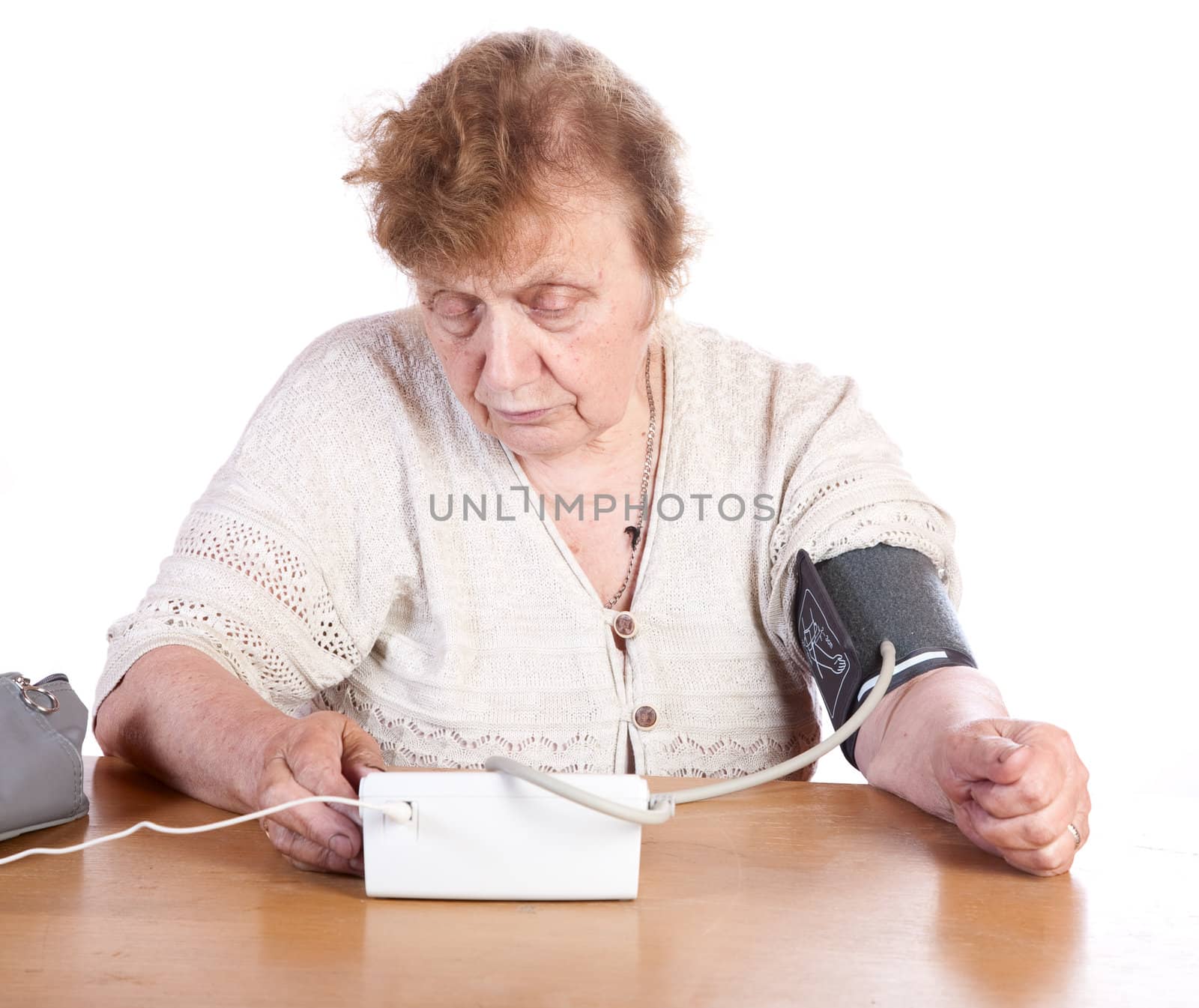 The old woman measures arterial pressure upon a white background