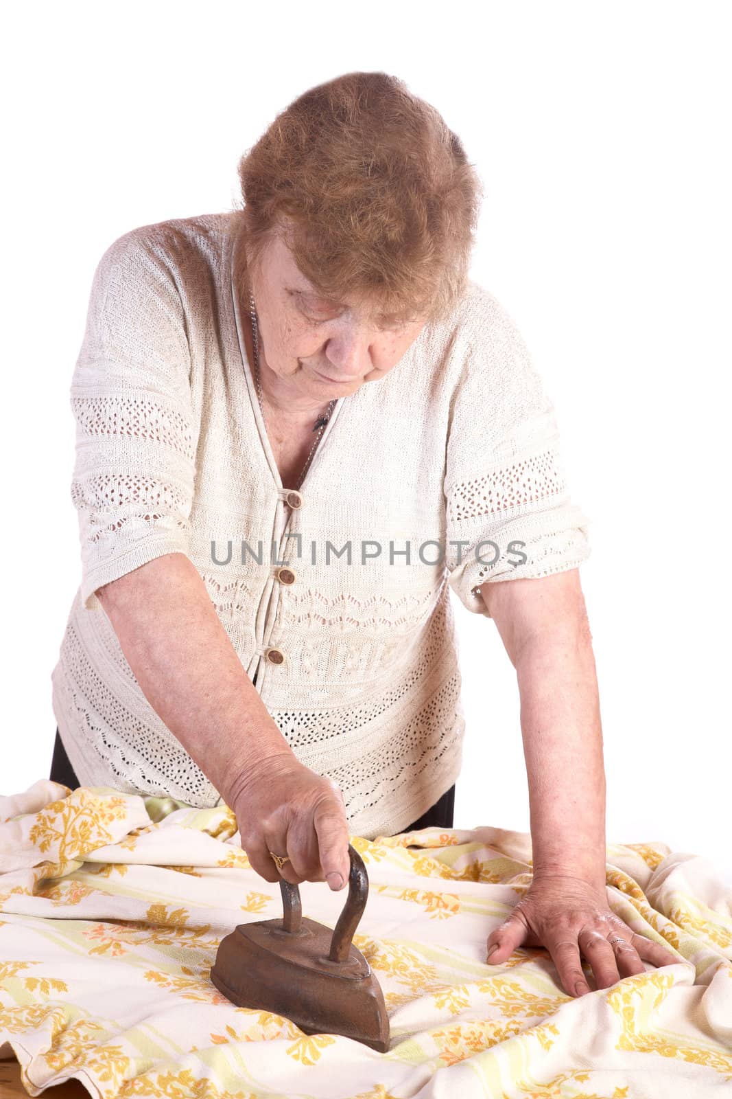 The old woman irons a cloth an ancient iron