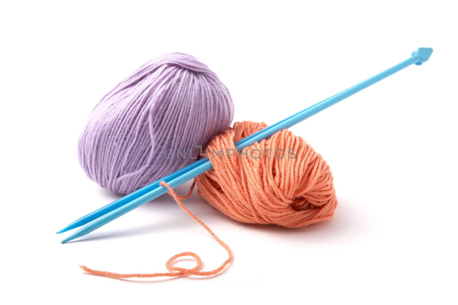 Balls of a yarn knitting spokes on white background