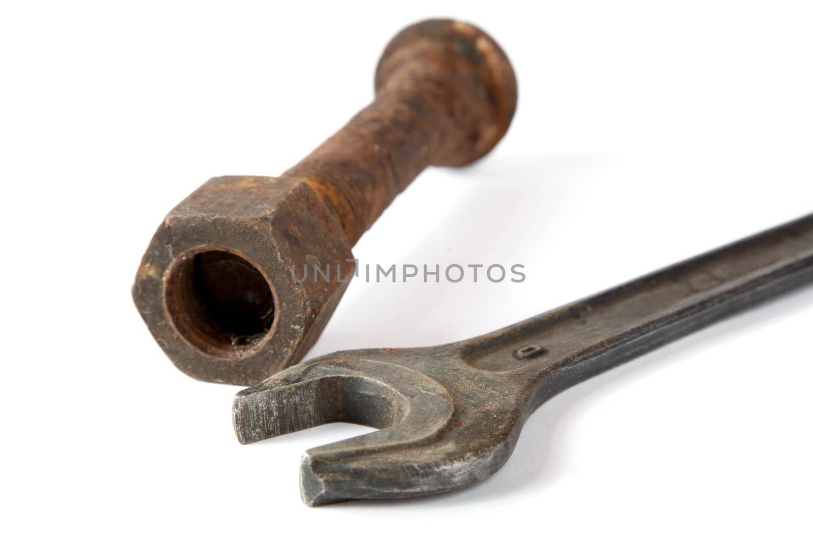 Wrench and rusty bolt with nut on a white background
