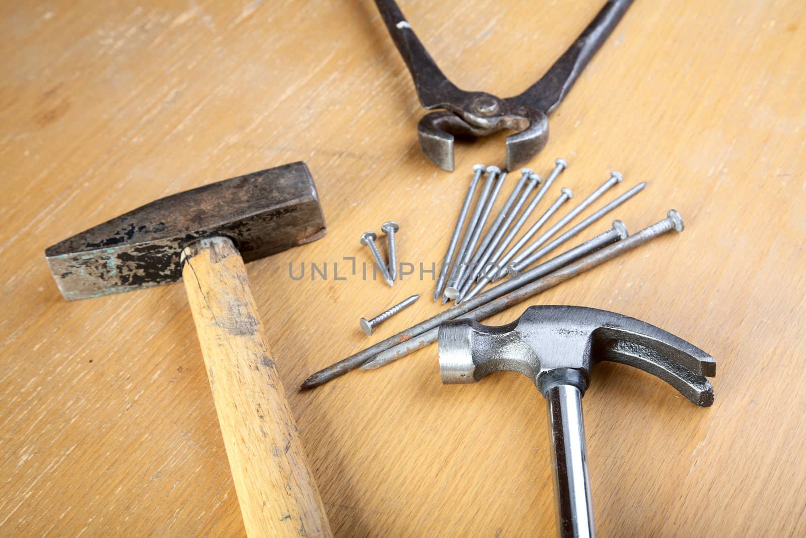 Hammer nails and pincers on a wooden table