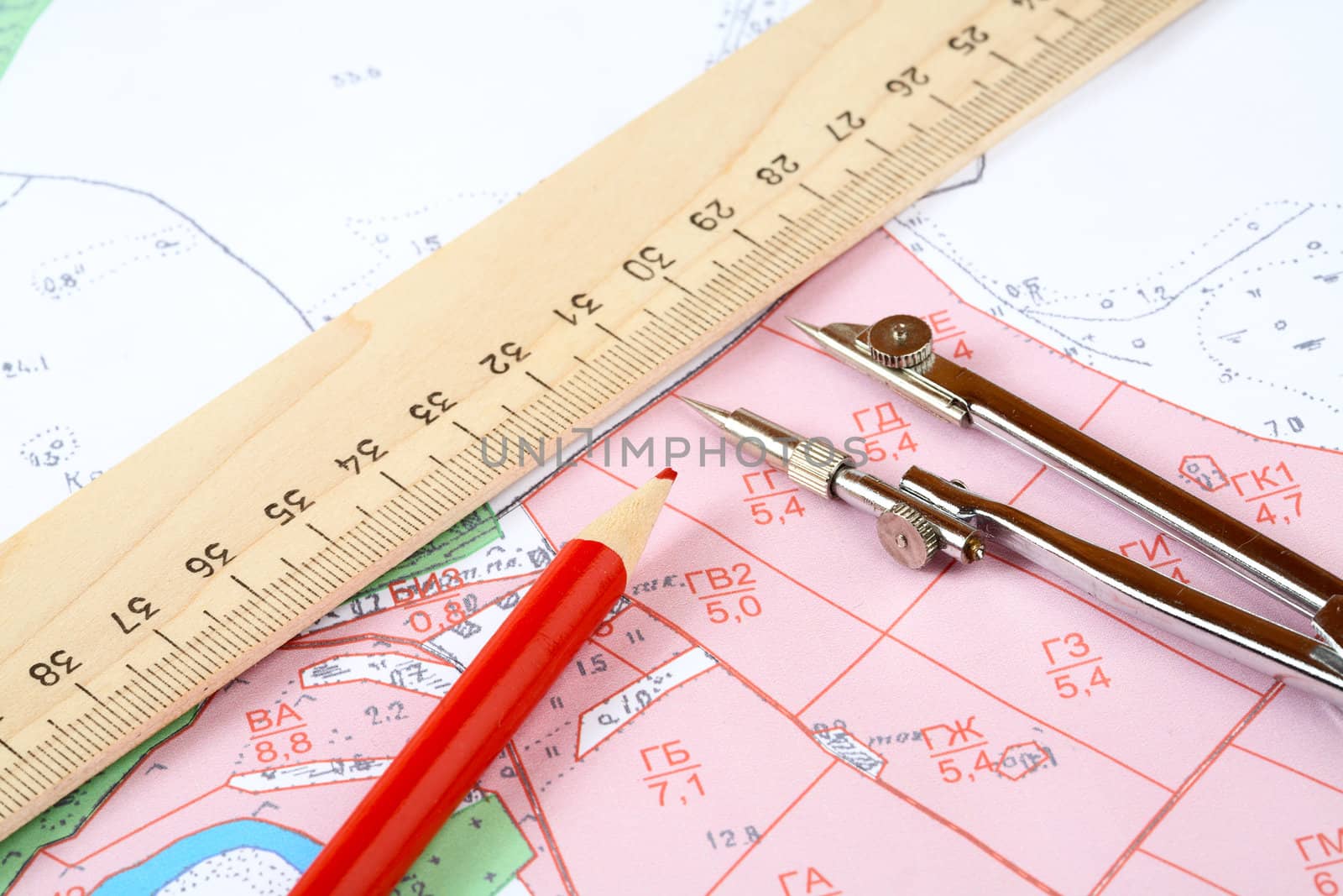 Red pencil  compasses and  ruler on a topographic map