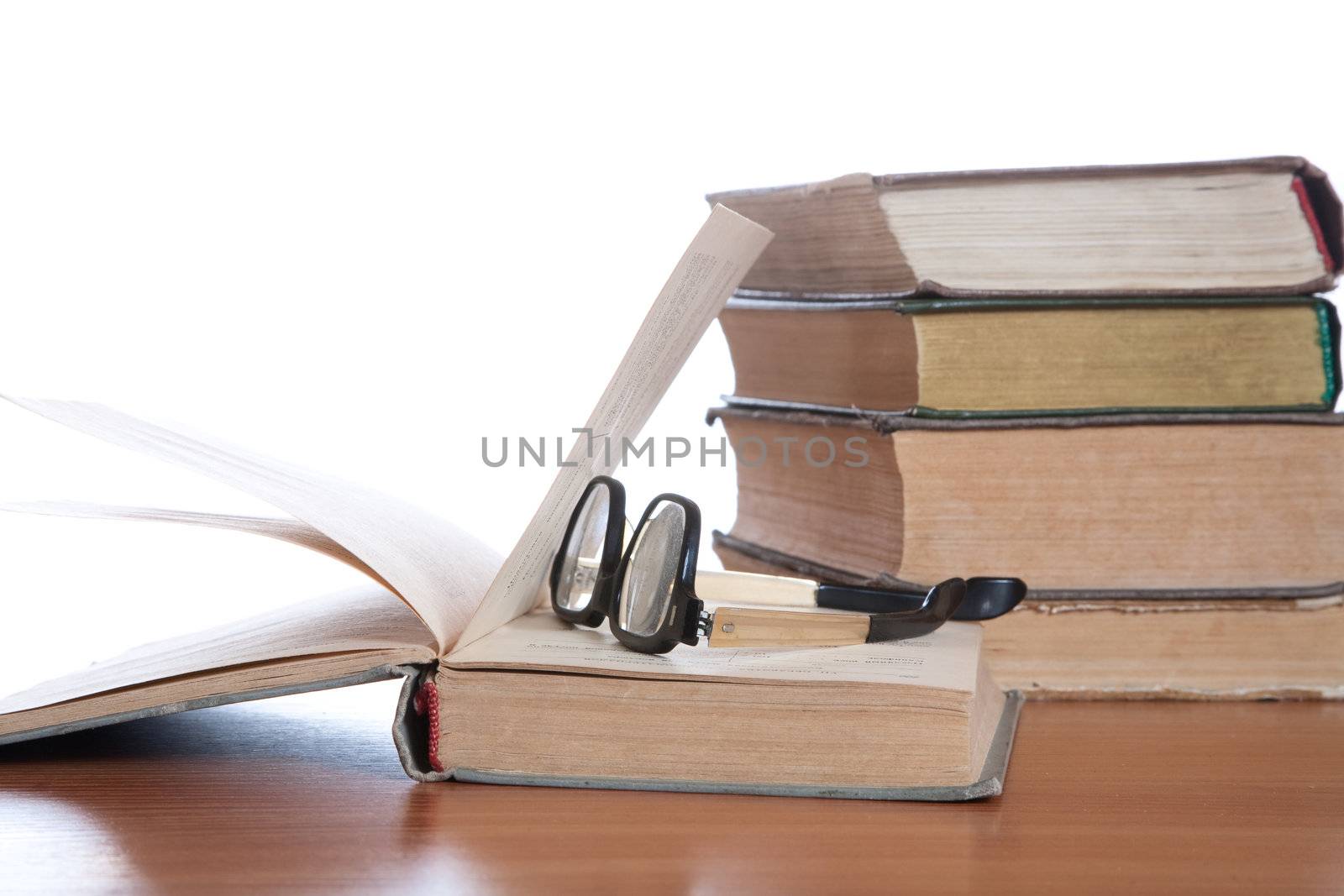 Old glasses and the old book on a white background