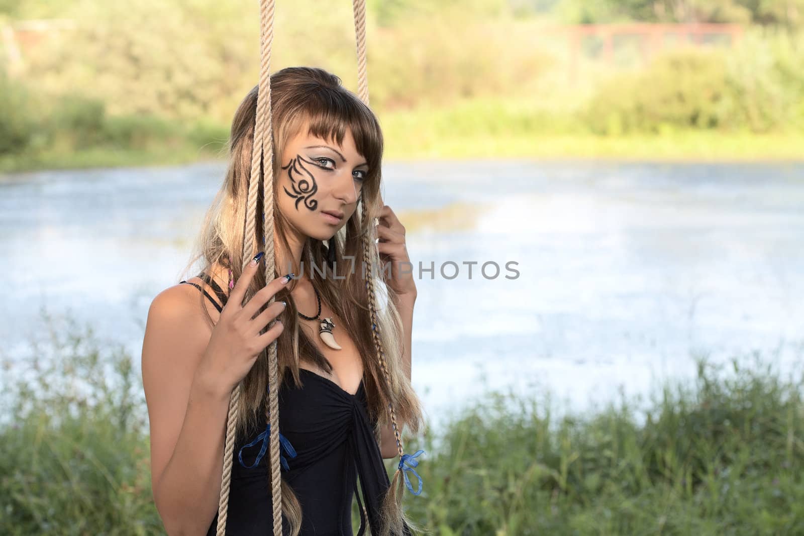 girl on  swing against a pond in the afternoon
