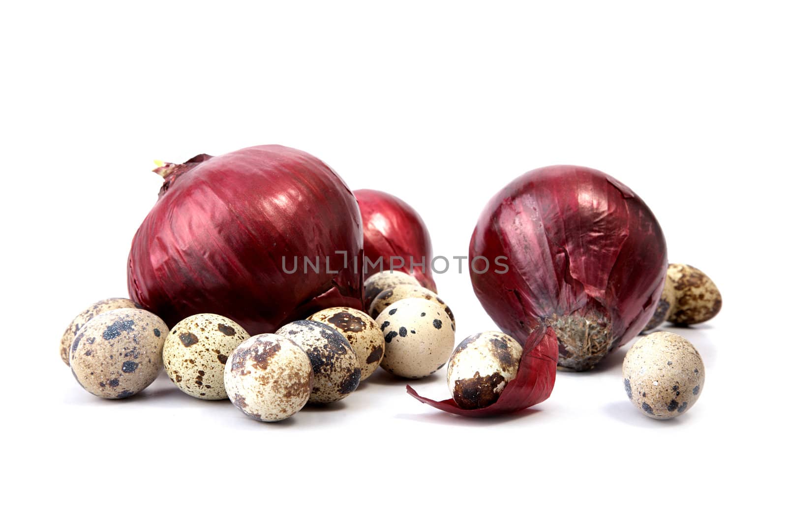 Red onions and quail eggs on a white background
