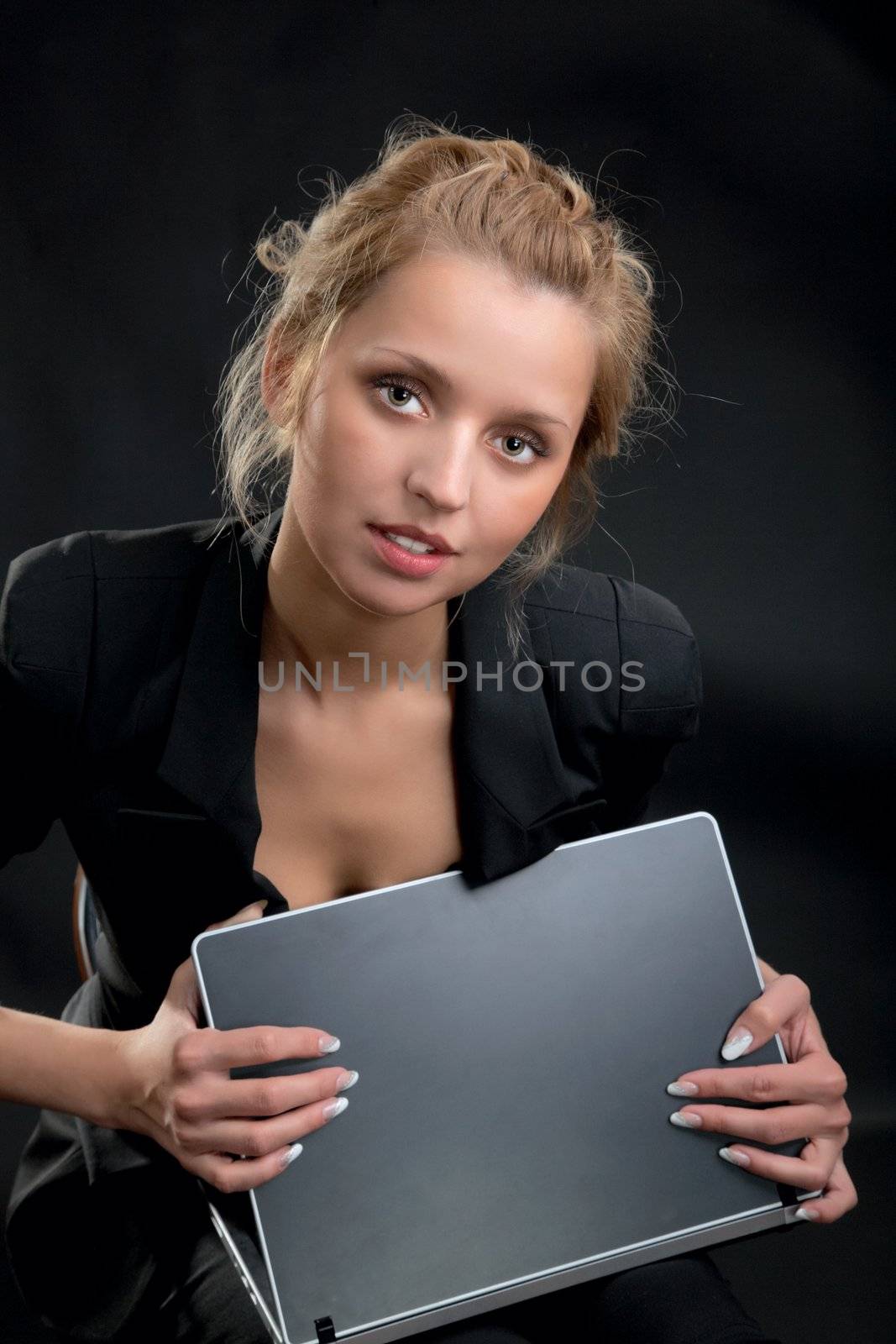 girl in a business suit with the laptop on  black background