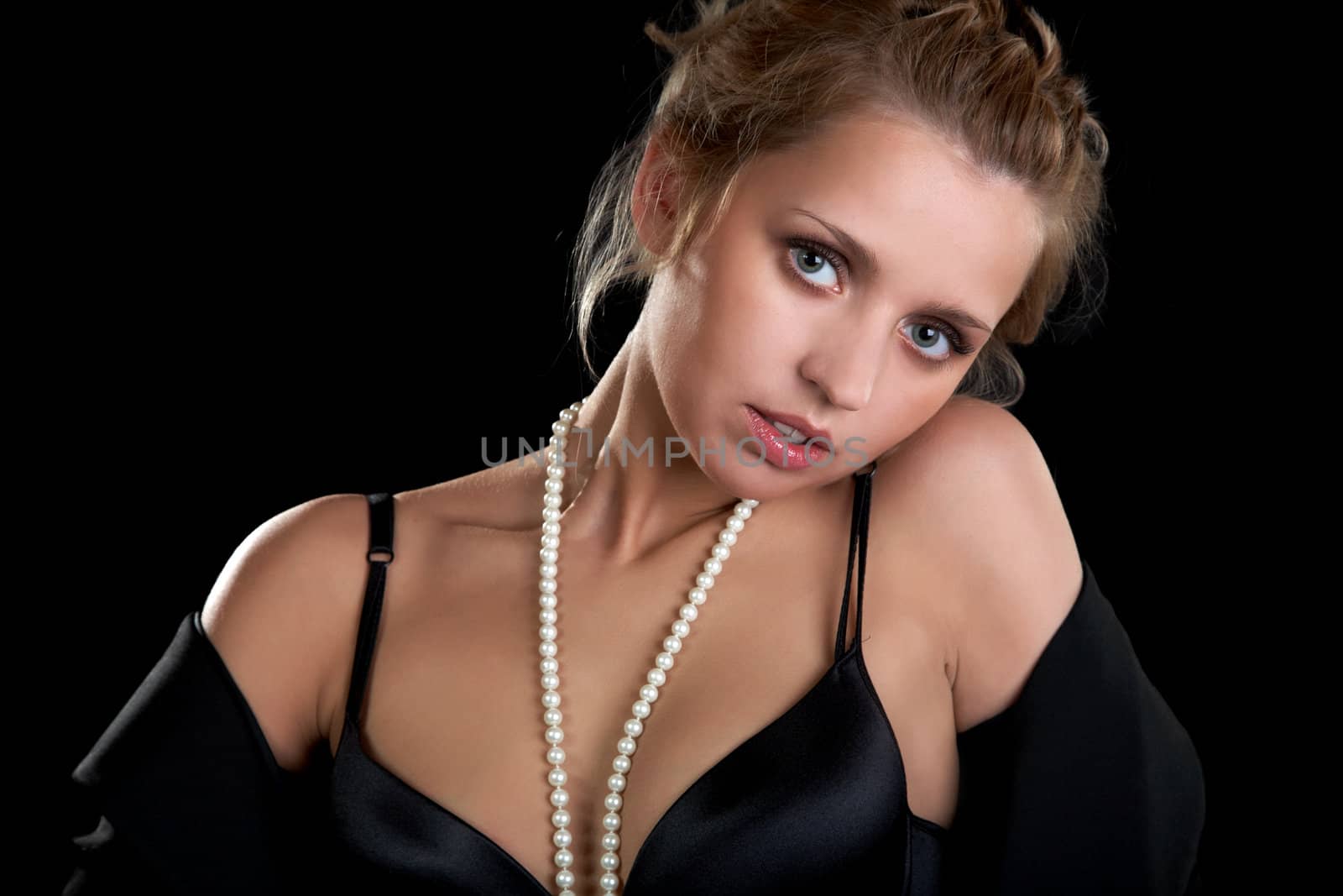 The girl in a black brassière against  dark background