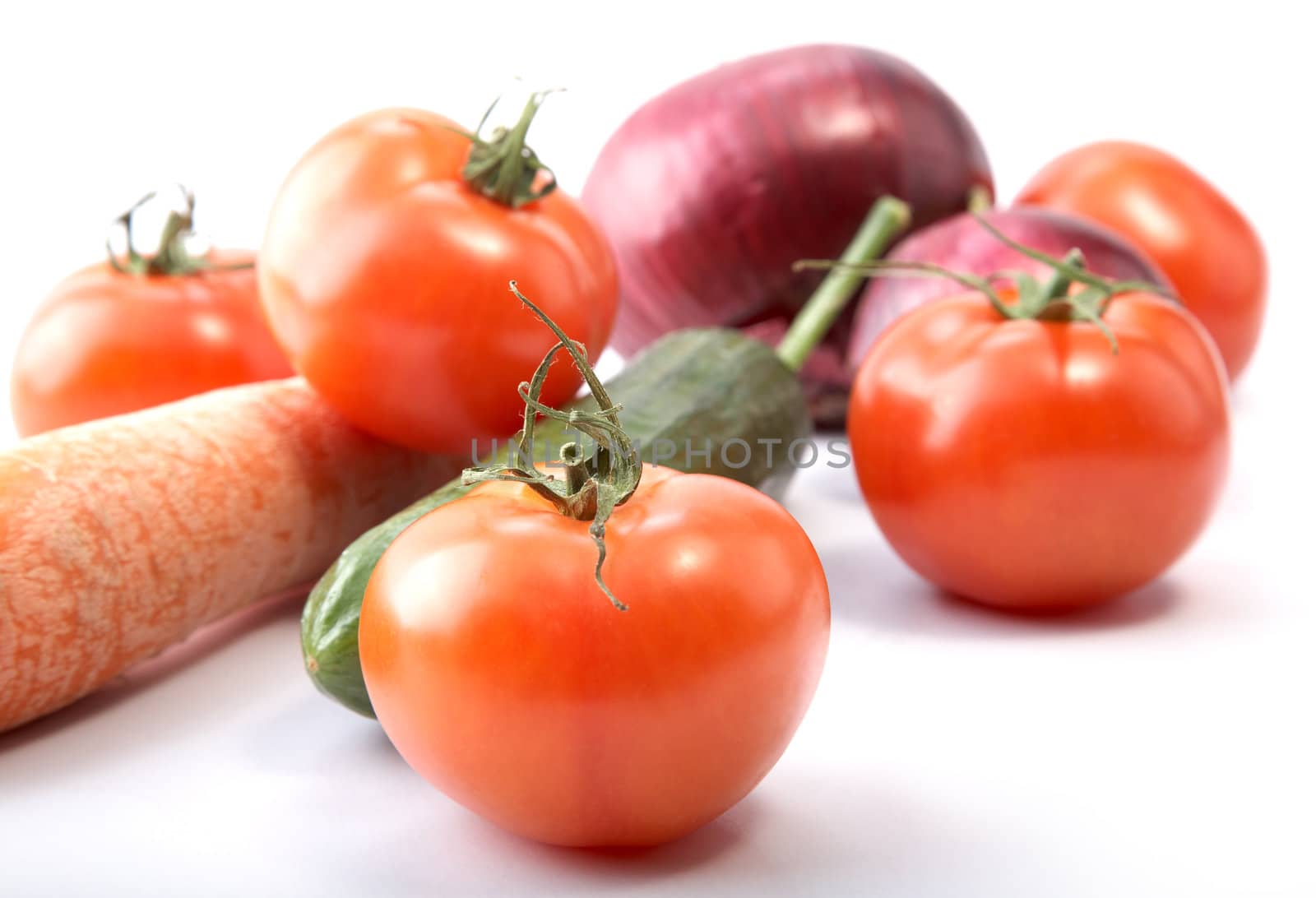Cucumber tomatoes and an onions on a white background