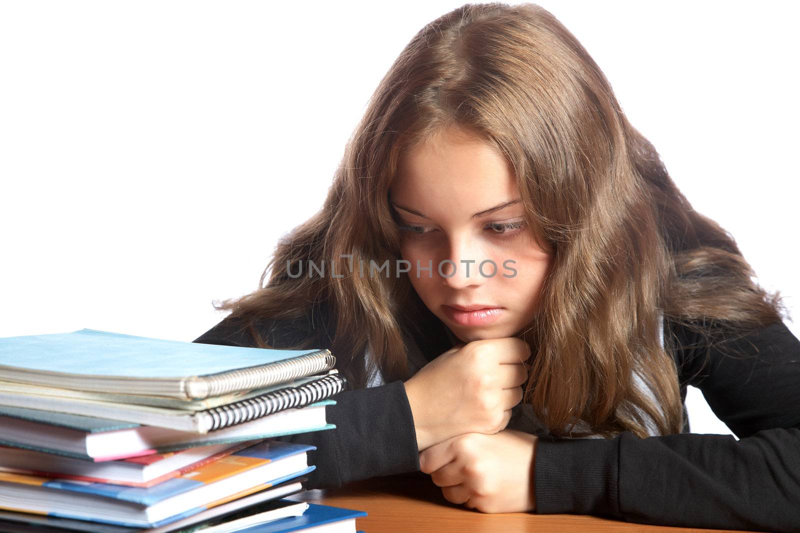 The girl-teenager looks at  pile of books on a white background