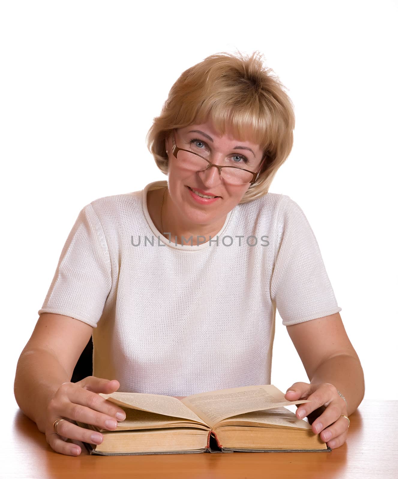 The mature woman with  book behind a table on white background