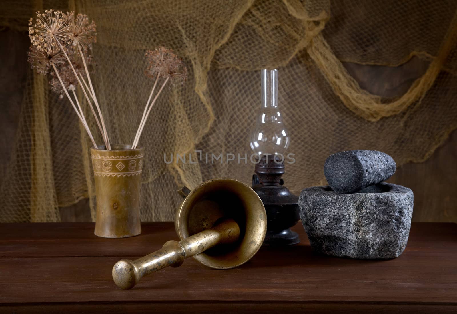 Still-life with mortars and an oil lamp on an old table