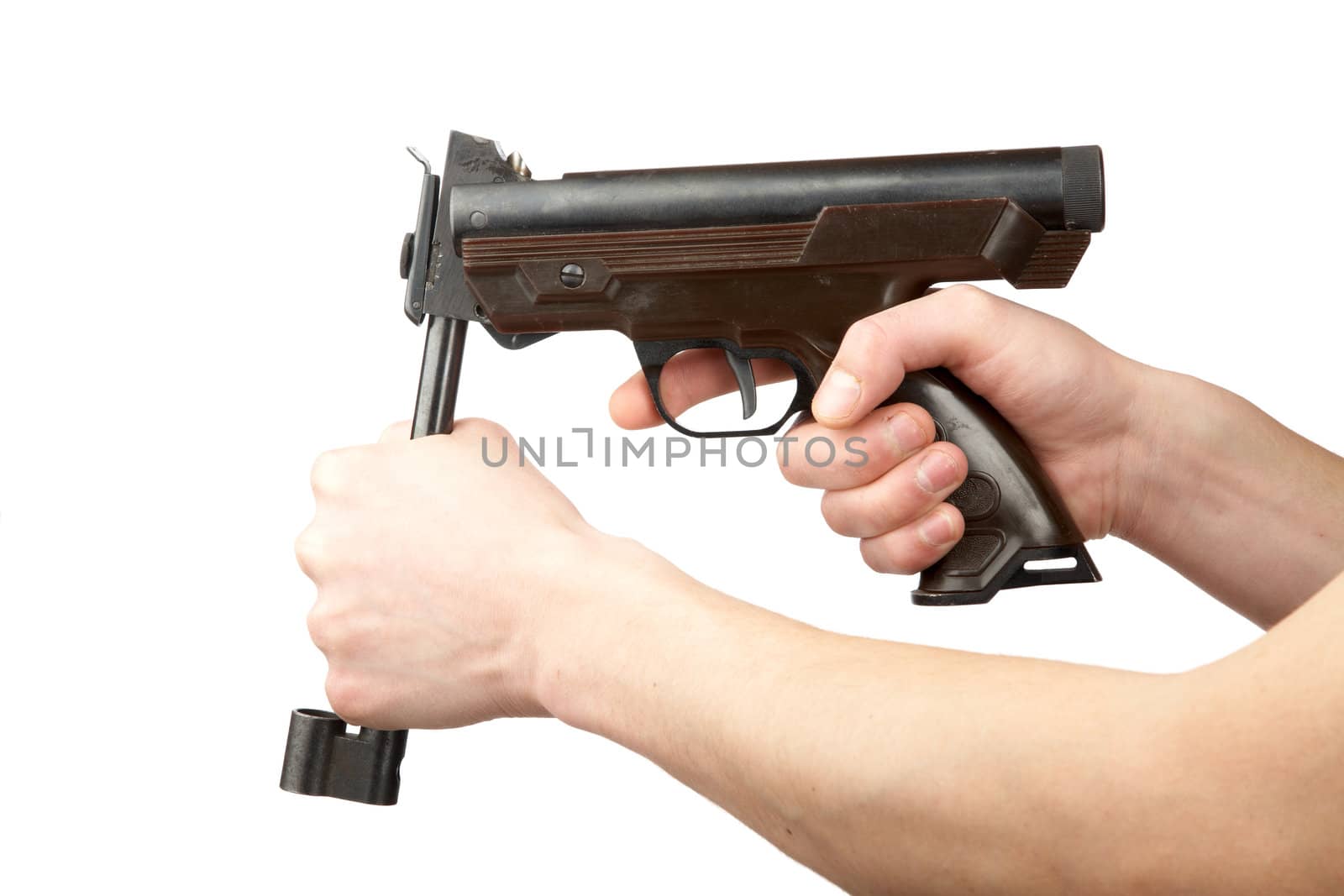 Man's hands charge a pneumatic pistol on a white background